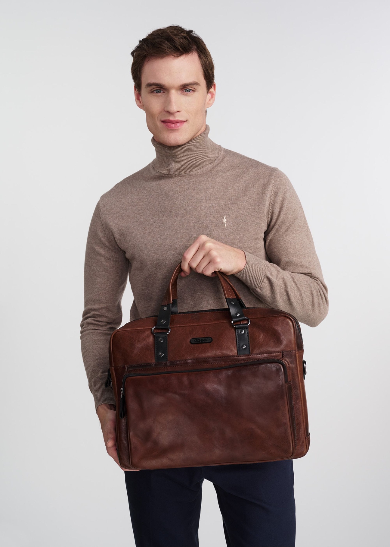 Brown leather men's bag TORMS-0100-1H(W26), product view in model's hand, on light background.