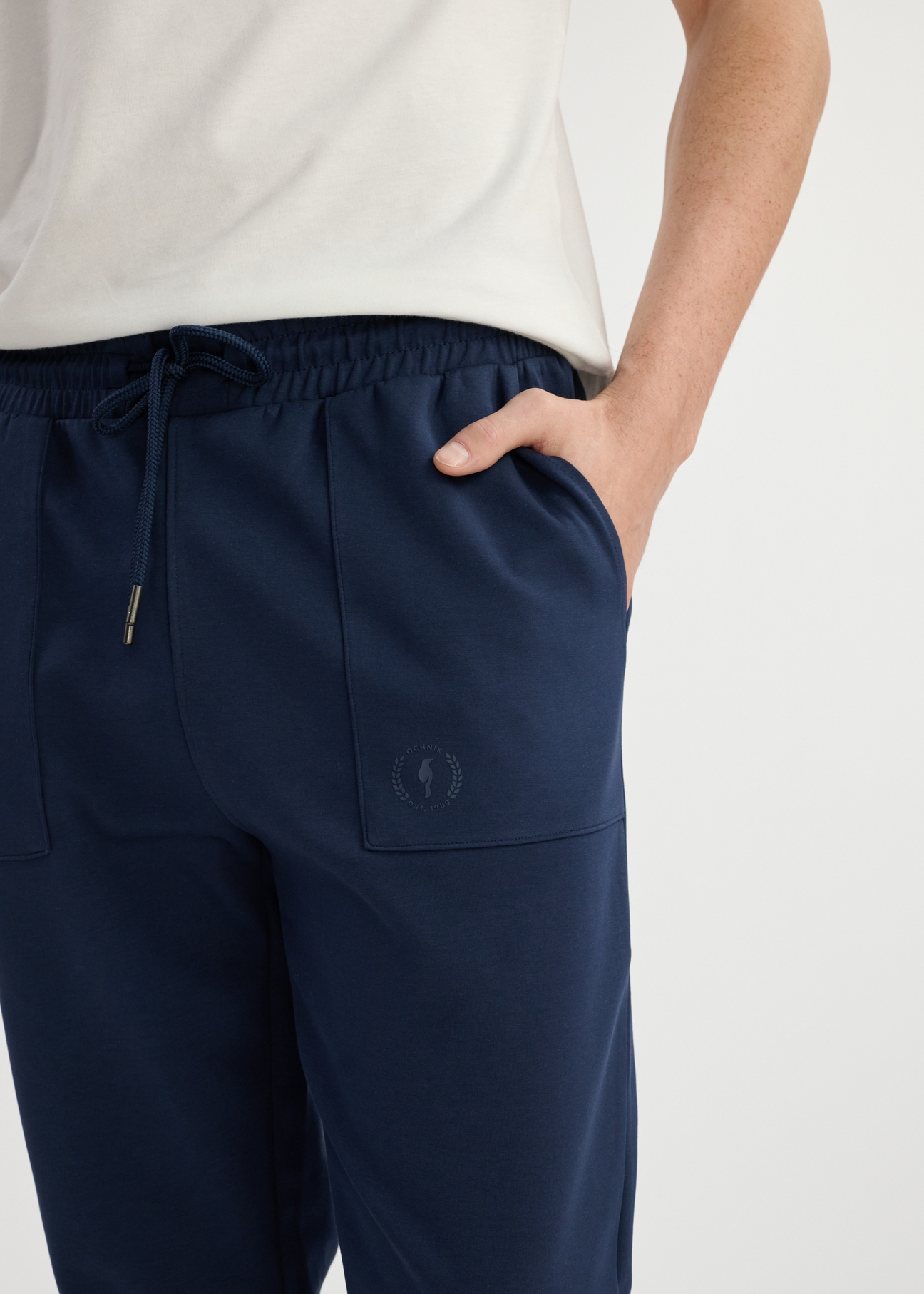 Navy blue men's sweatpants SPOMT-0109-69(W25) - close-up of front detail on model on white background.