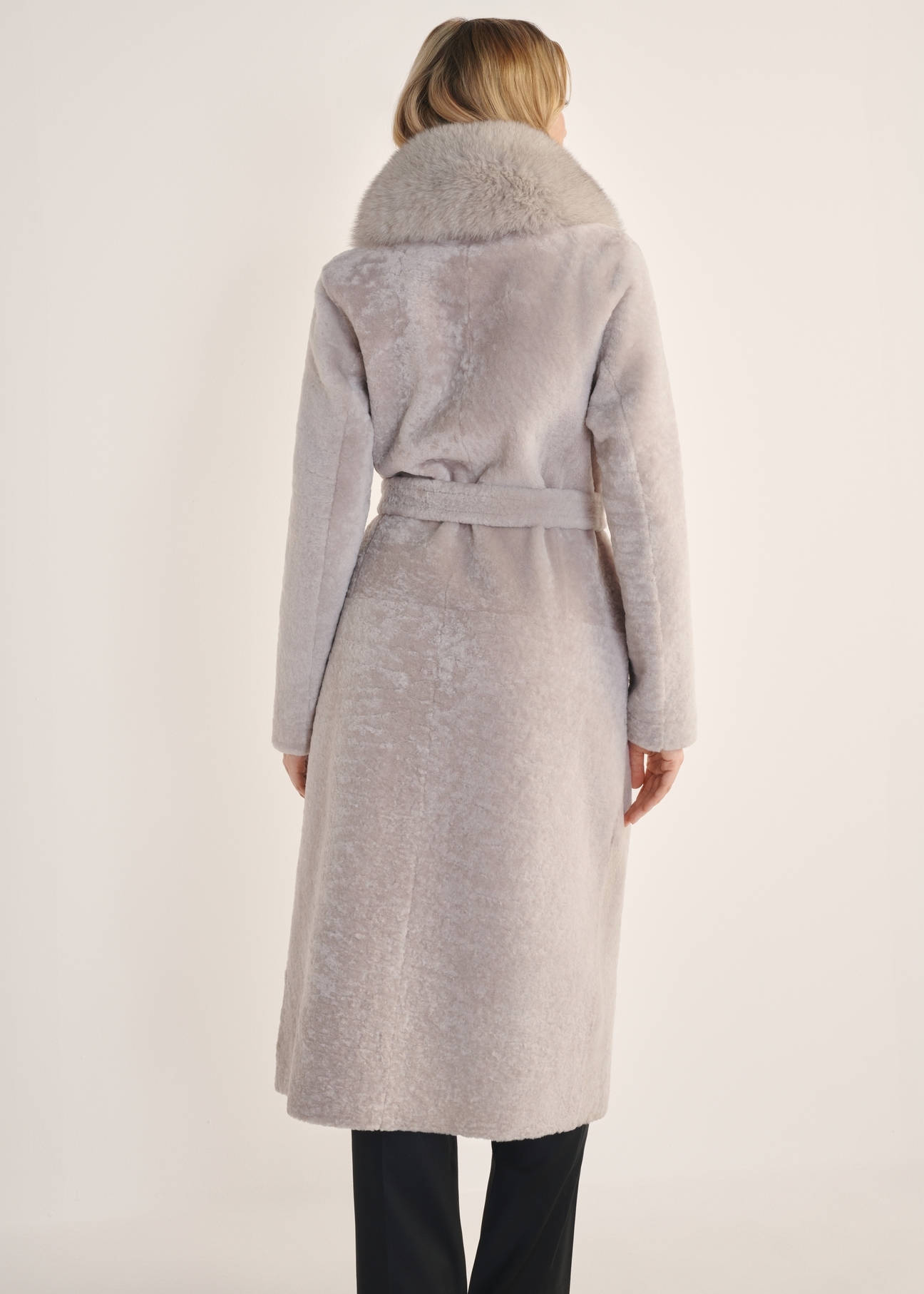 Jasnobeżowy dwustronny długi kożuch damski KOZDS-0089-3037(Z25) - widok produktu z tyłu na białym tle. Widoczna cała sylwetka. 