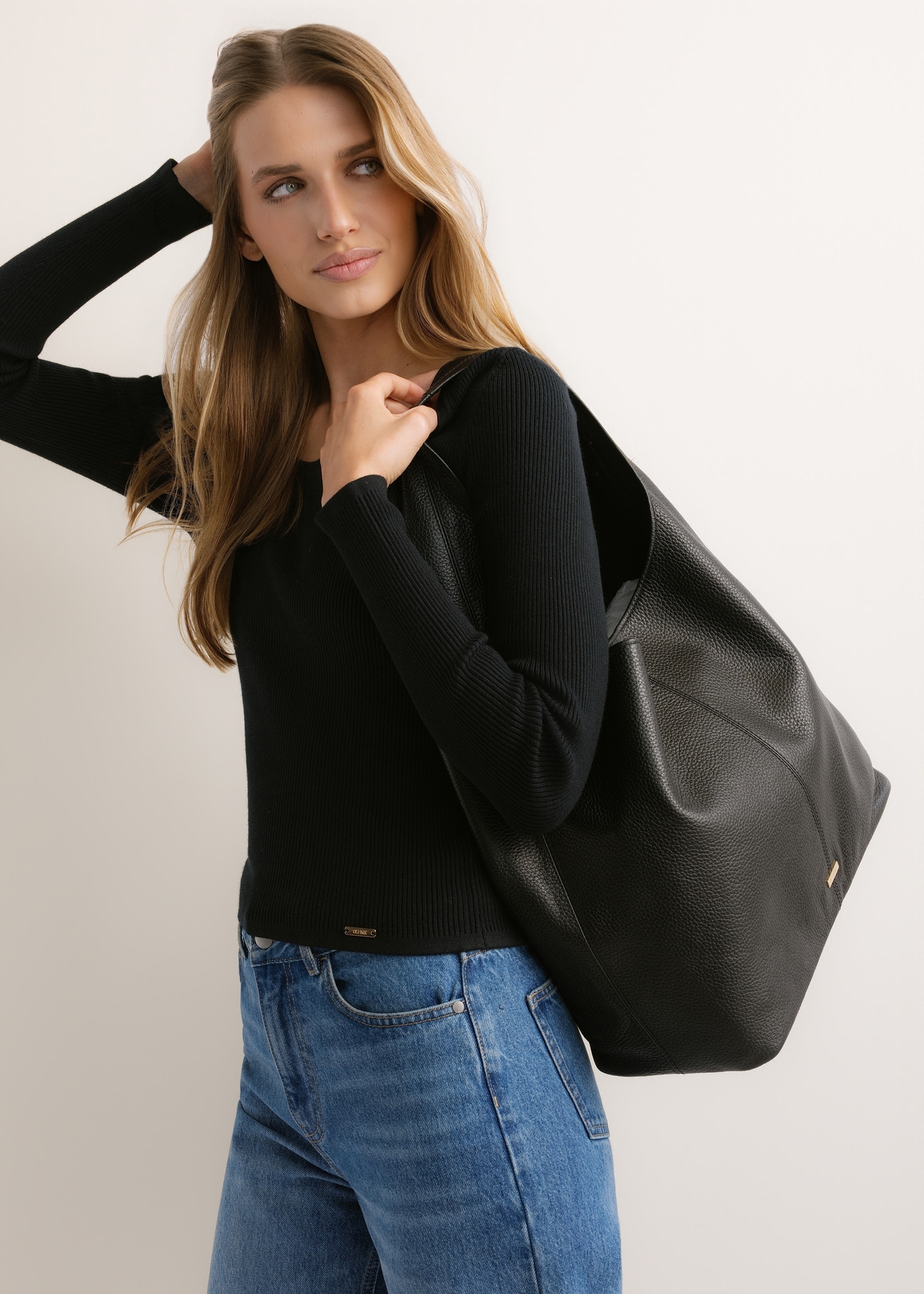 Black leather shopper bag TORES-1372-9I(Z26), diagonal view of the product on the model. Half of the silhouette visible.
