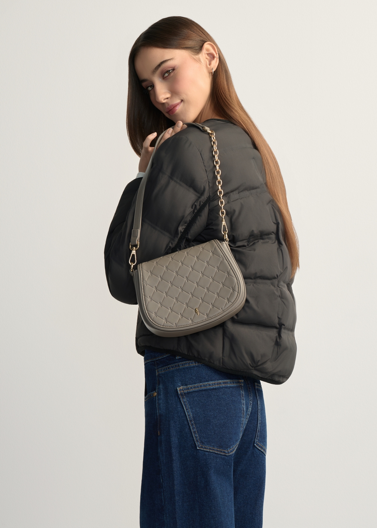 Light brown women's messenger bag TOREC-1179-1K(W26), product view on model's shoulder. Half of silhouette visible.