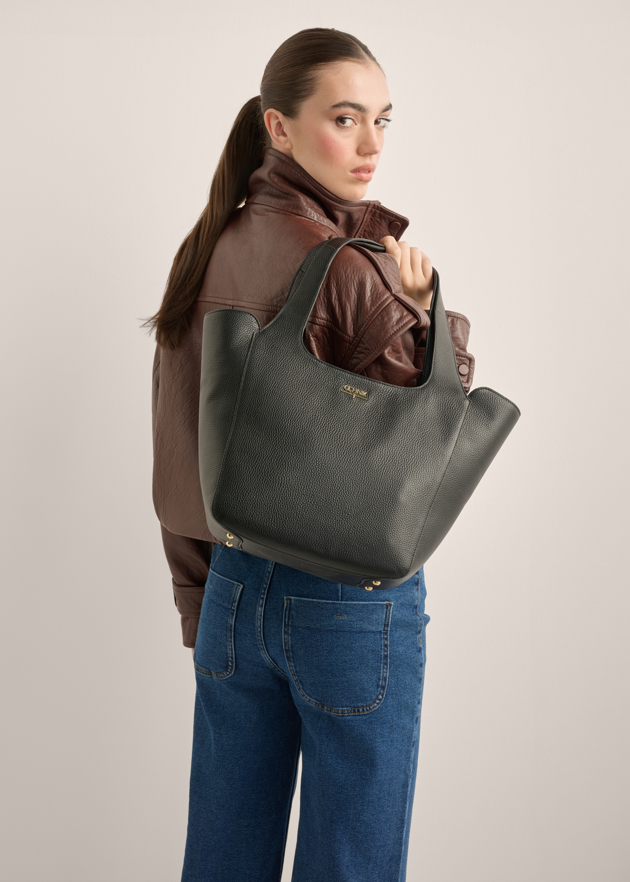Women's black leather shopper bag TORES-1340-9I(Z26), front view of the product on a model. Half of the silhouette visible.
