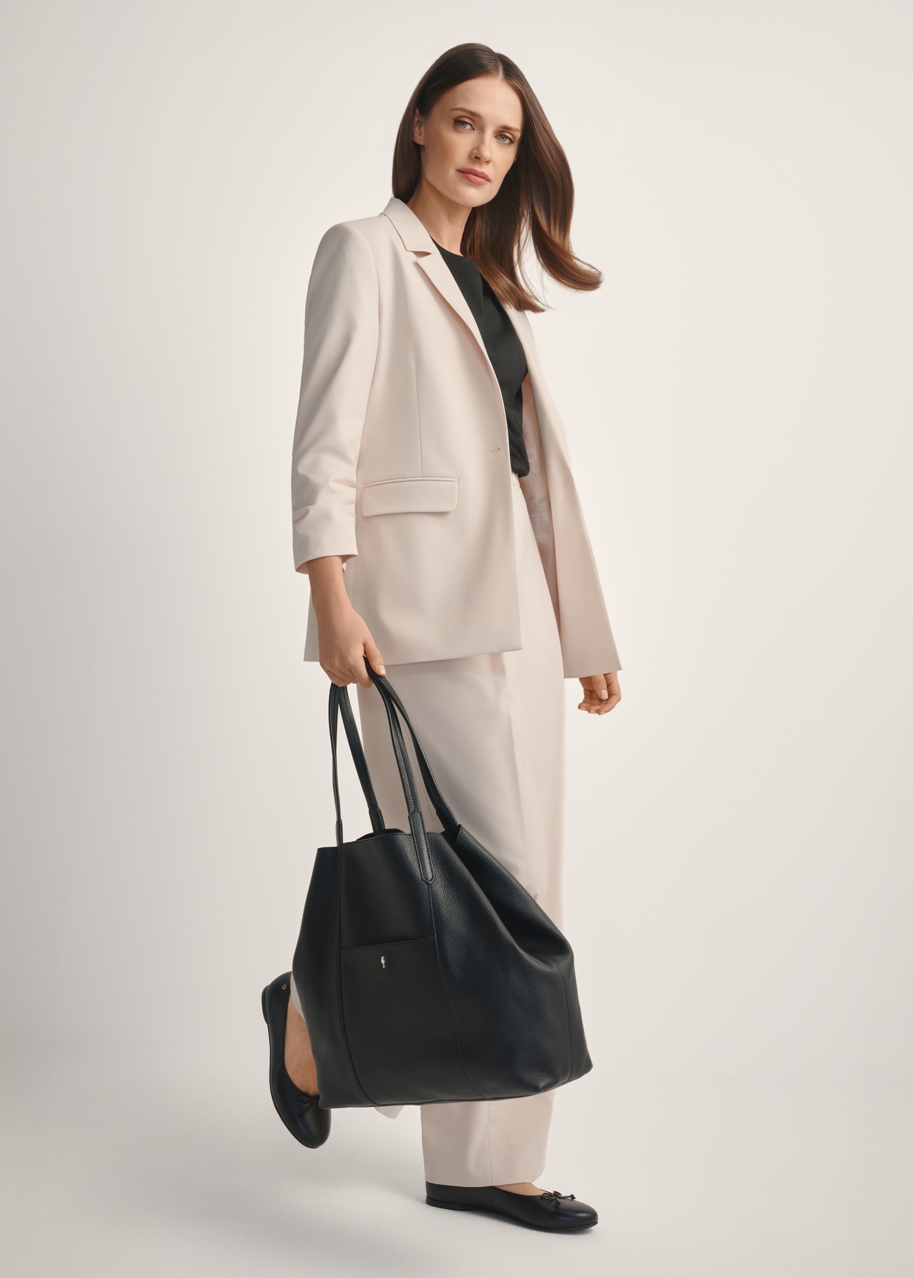 Large black leather shopper bag TORES-1212-9I(W26), diagonal view of the product on the model, the entire silhouette is visible.