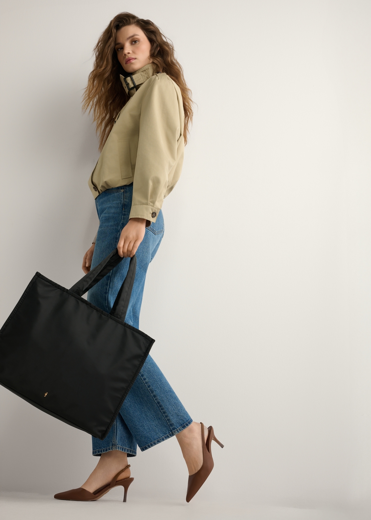 Black large women's bag TOREN-0343-99(W26), product view from the front on the model, the entire silhouette is visible.