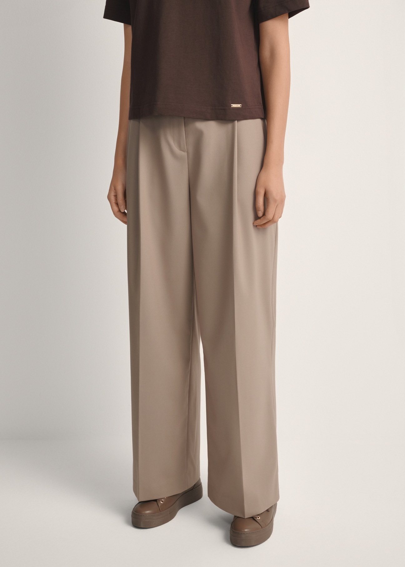 Women's dark beige trousers SPODT-0119-1K(W26), front view of the product on the model. Half of the silhouette visible.