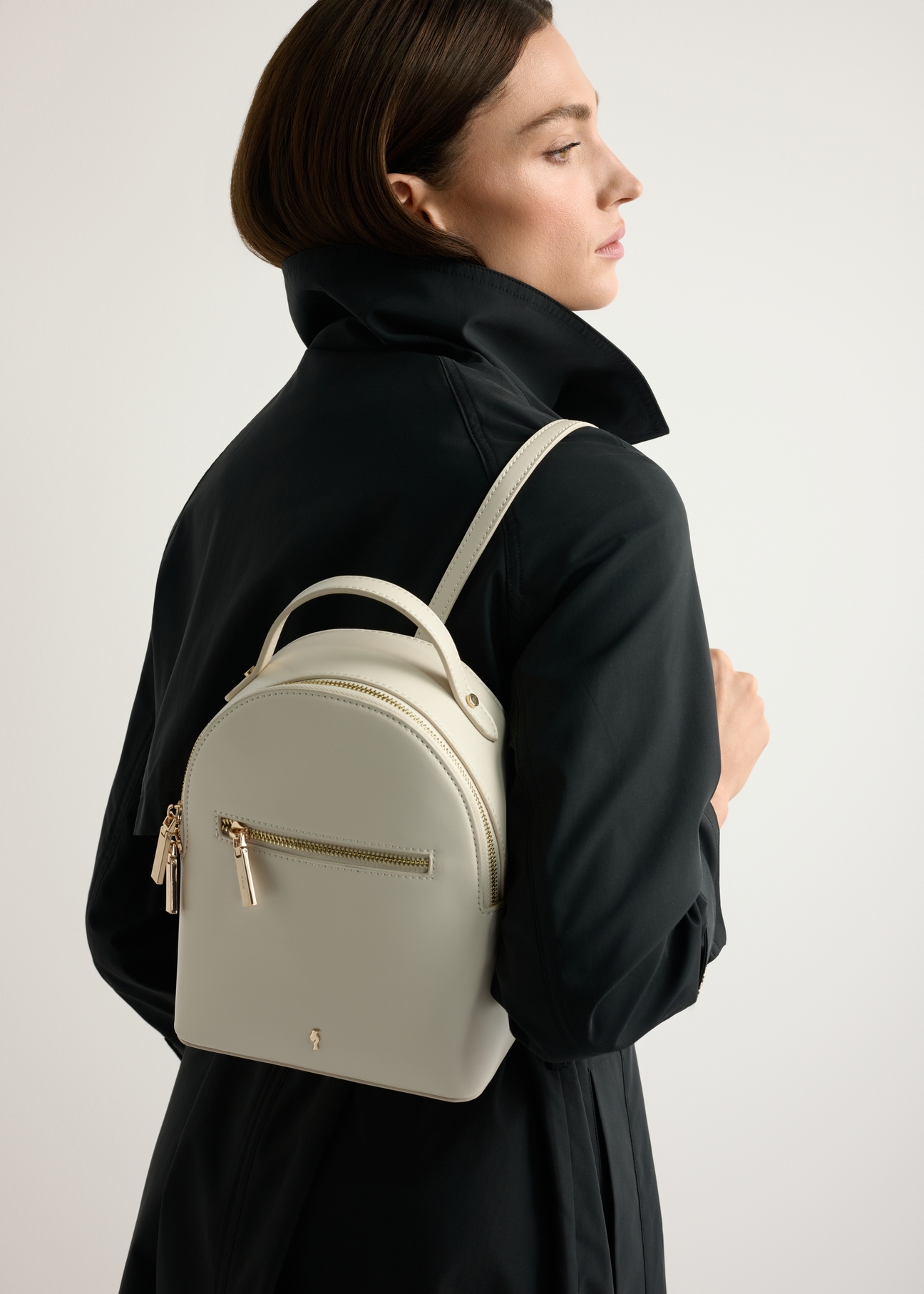 Small cream women's backpack TOREC-1128-0B(W26) - front view of the product, on a model, against a light background. Half-length silhouette visible.