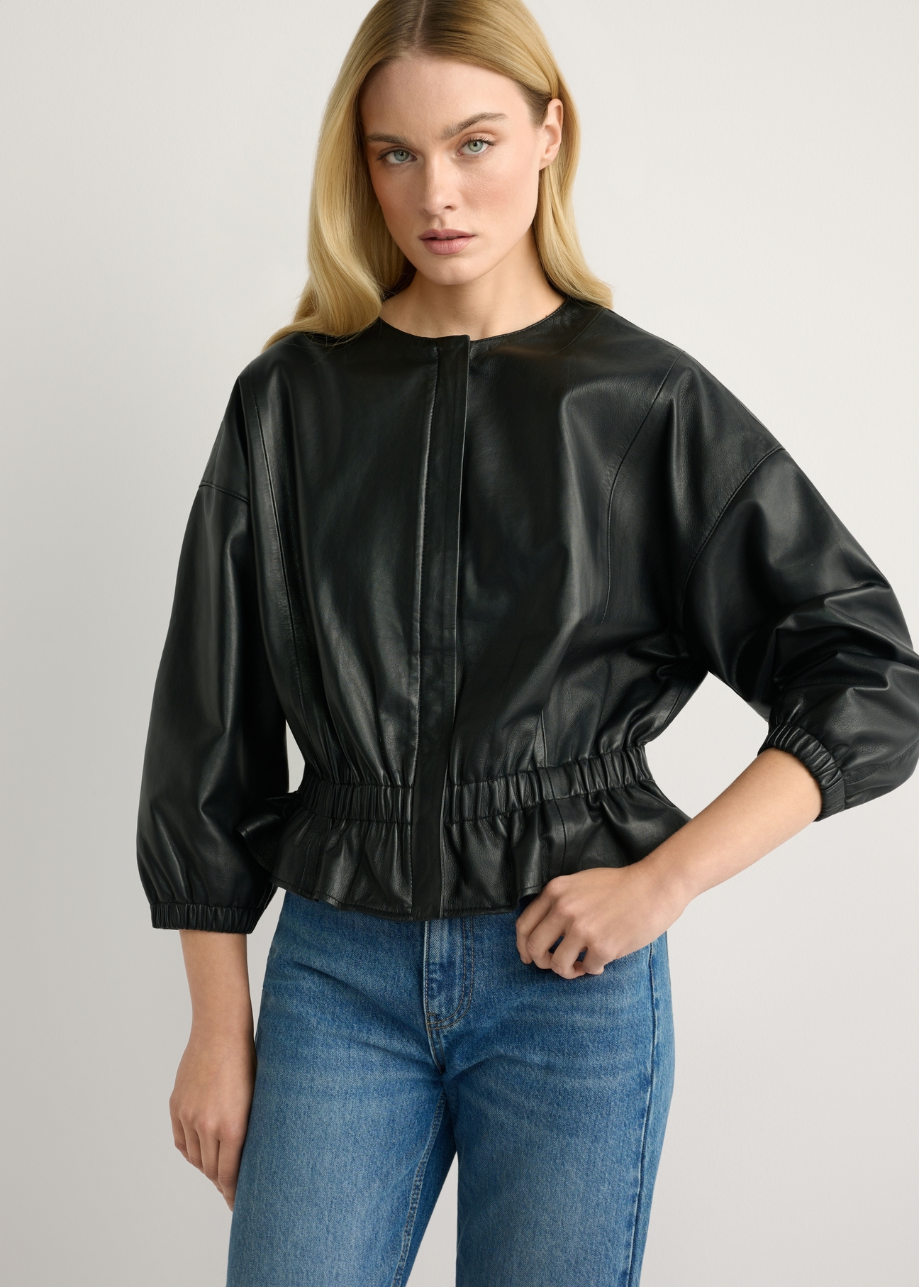 Women's black leather jacket KURDS-0570-99(W26), front view of the product on the model. Half of the silhouette visible.