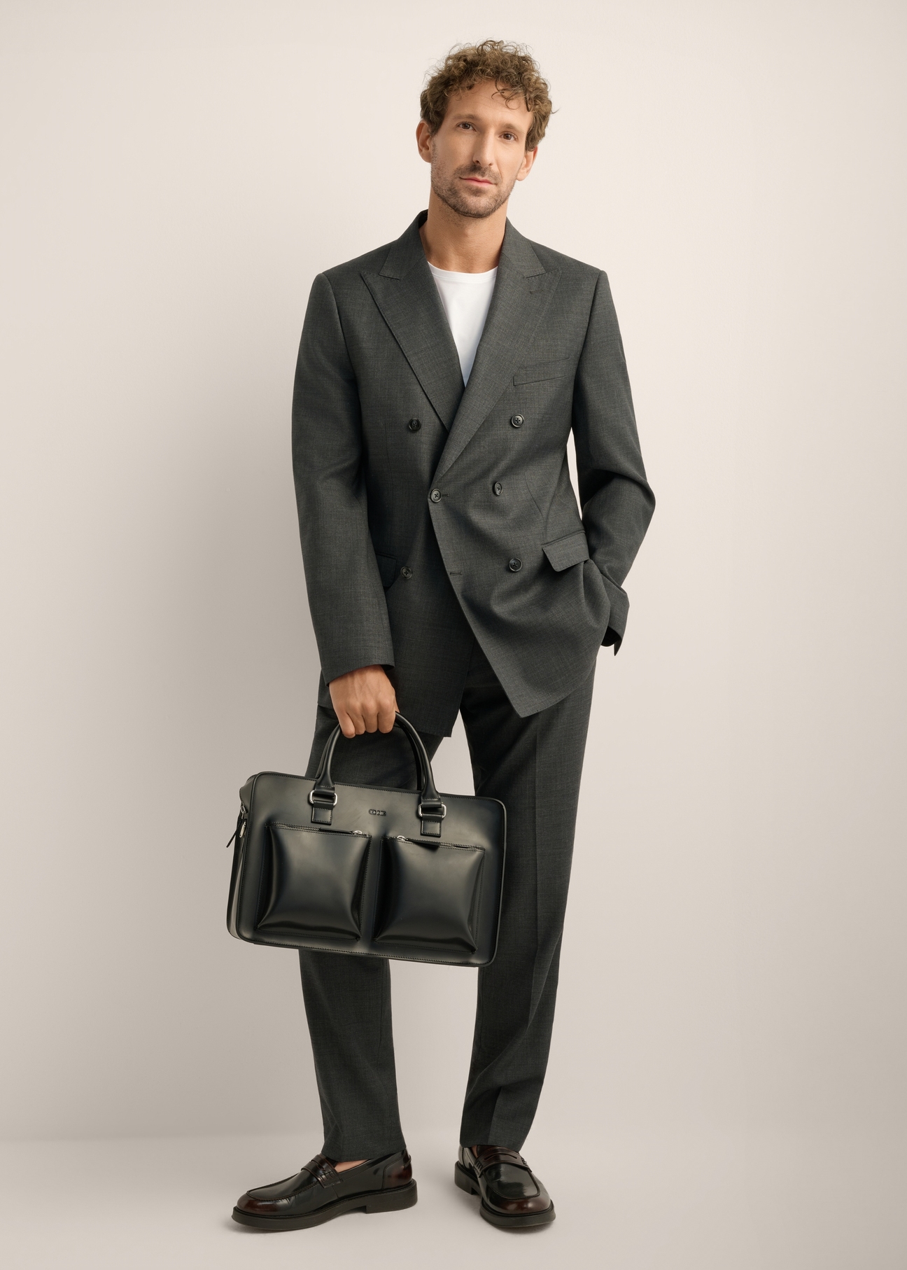 Black leather business briefcase TORMS-0531-99(Z26). Front view of the product on a model. Full-body view.
