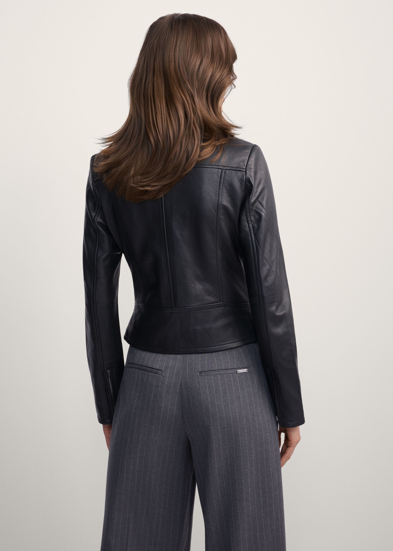 Women's leather biker jacket KURDS-0274-99(KS), back view of the product on the model. Half of the silhouette visible.