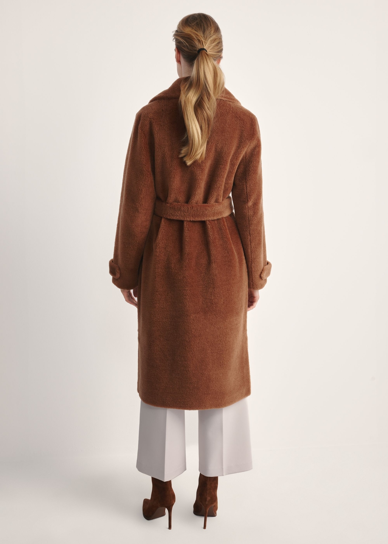 Long woolen fur coat in camel color FUTDW-0019A-1D(Z26)  - product view from the back on the model on a white background. The whole silhouette is visible.