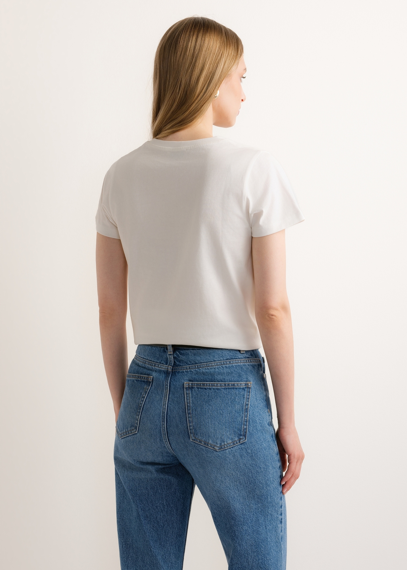 Cream women's T-shirt with print TSHDT-0166-0B(Z26) - back view of the product, on a model, against a light background. Half of the silhouette visible.