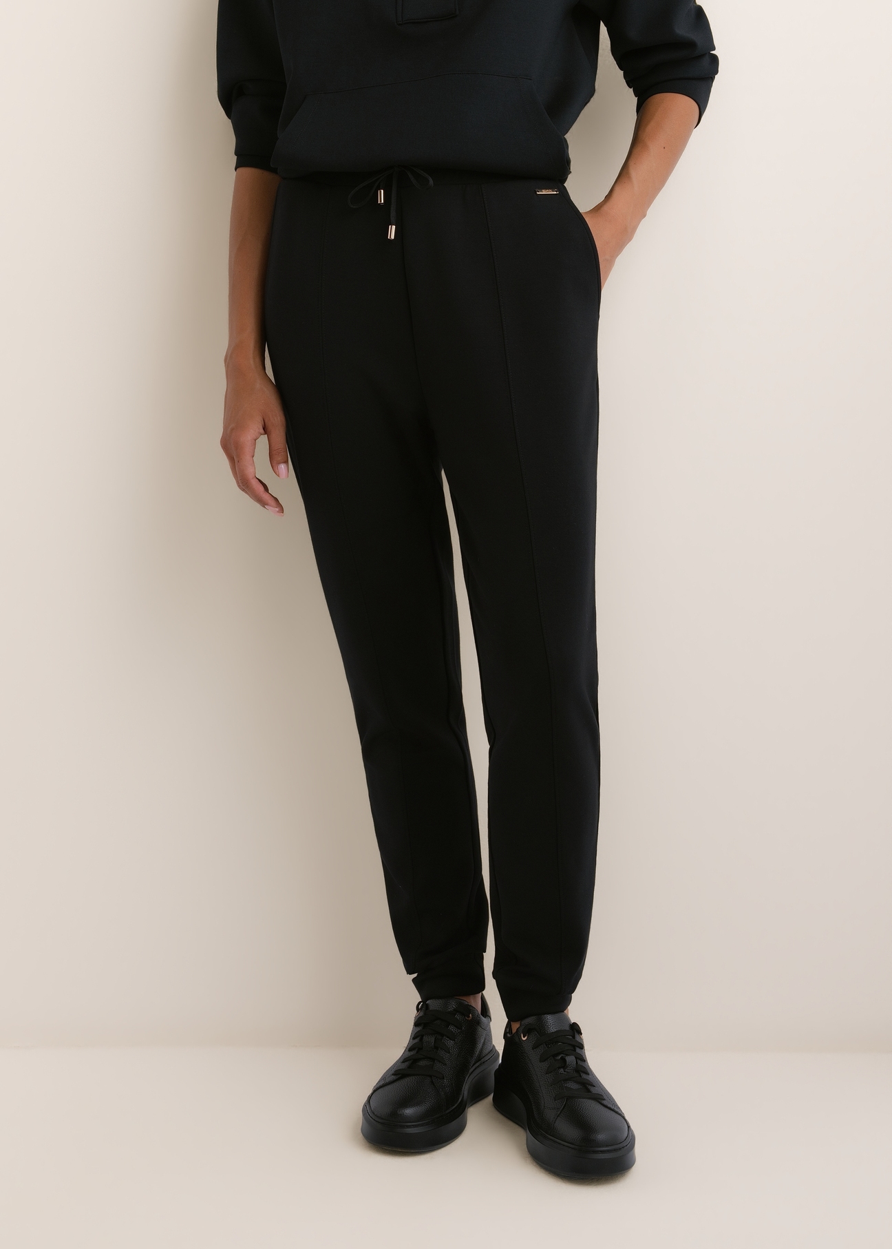 Women's black trousers SPODT-0108-99(W26), front view of the product on the model. Half of the silhouette visible.