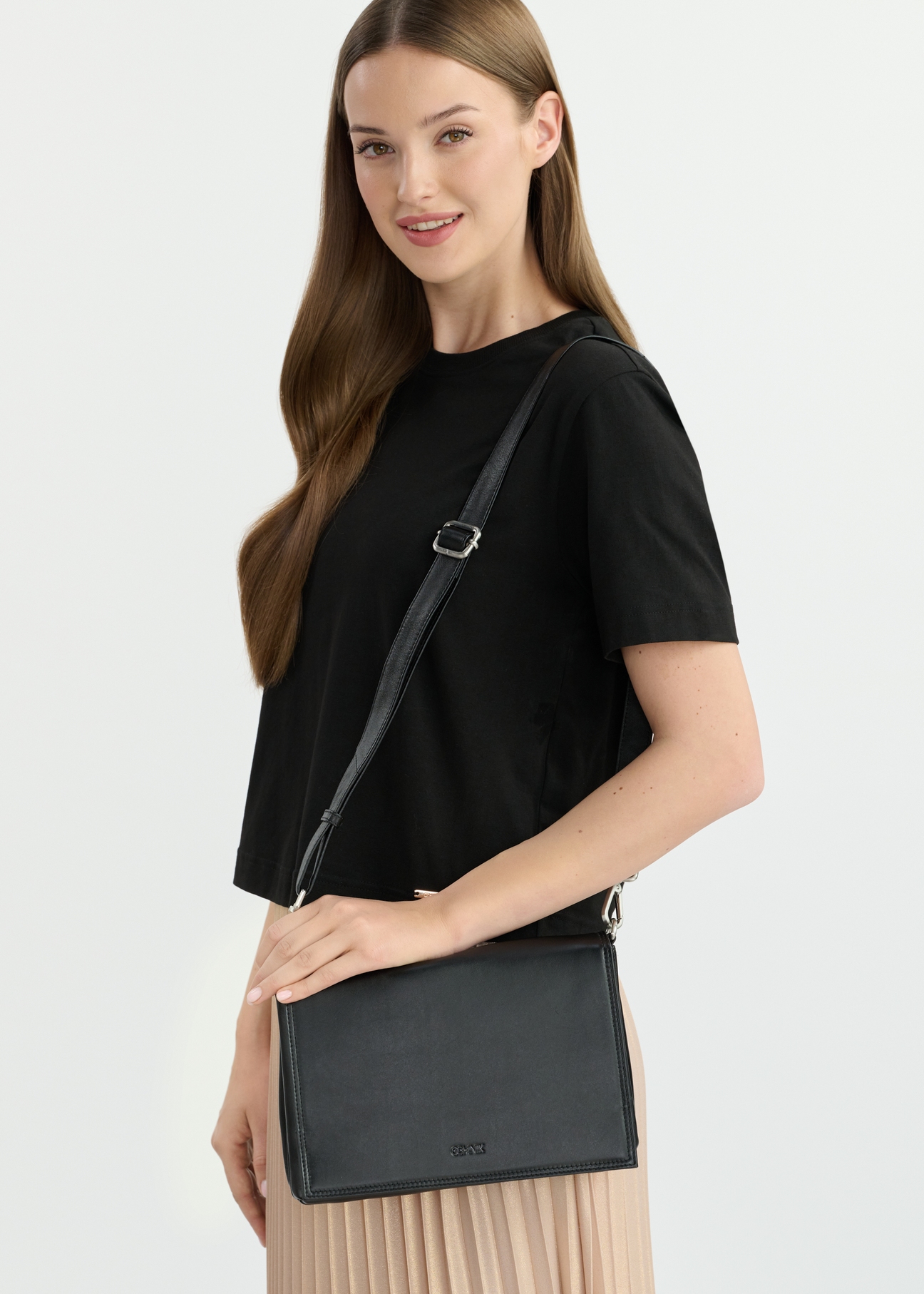 Black leather women's messenger bag TORES-1083-99(W25), front view of the product on the model. Half of the silhouette visible.