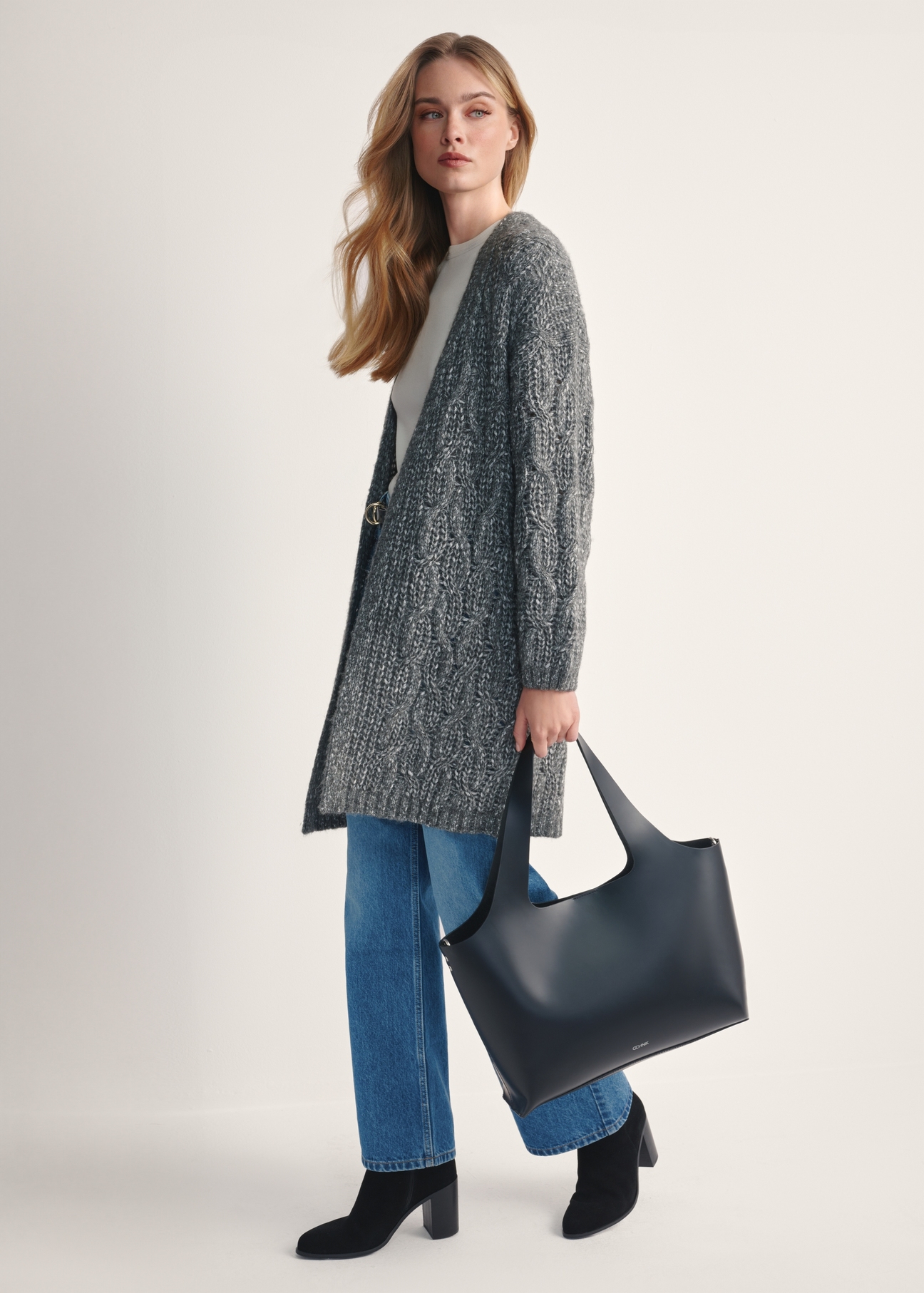 Black large leather shopper bag TORES-1140-99(Z25), view of the product in the model's hand on a light background.