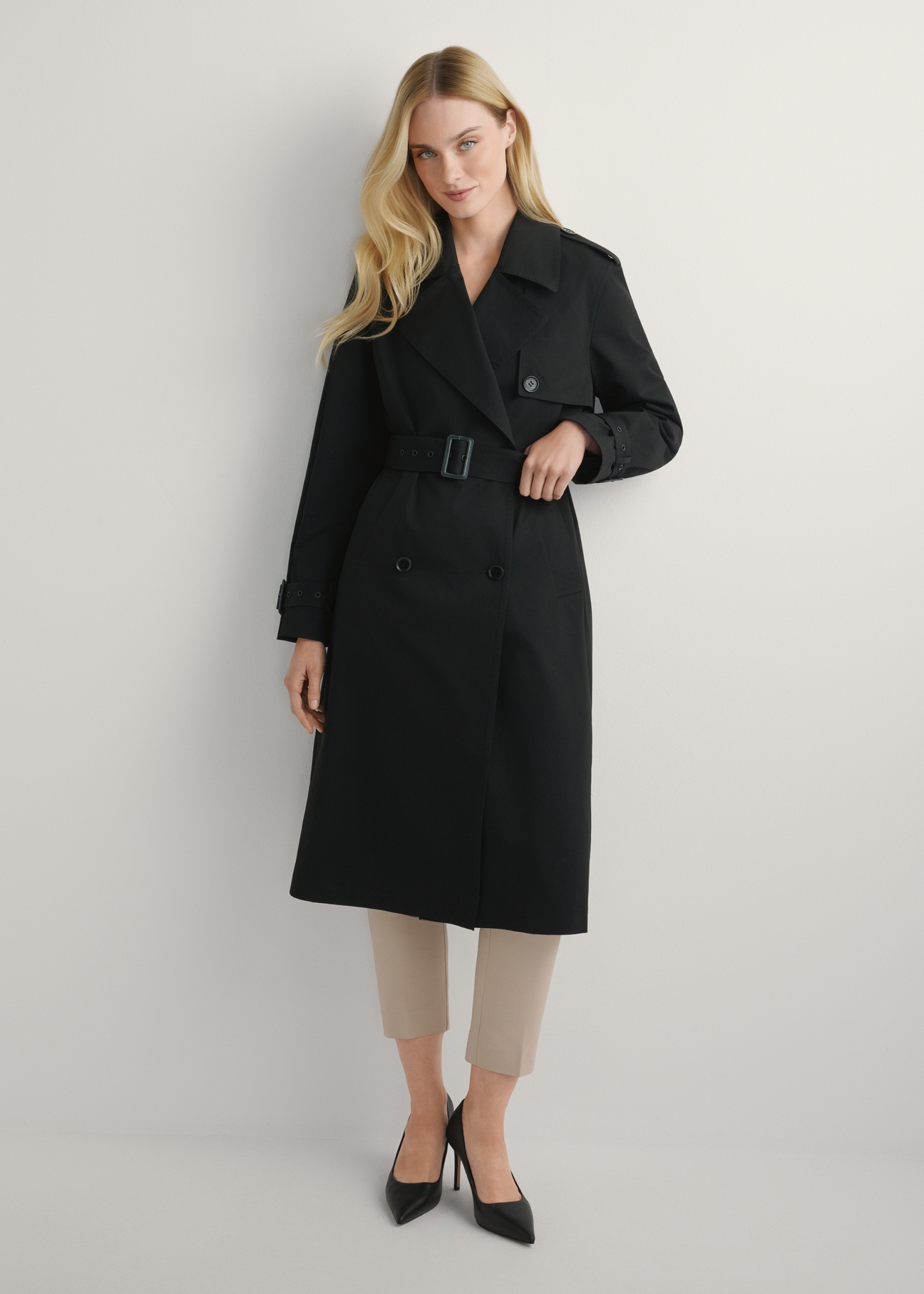 Long black women's jacket in the form of a coat KURDT-0512-99(W25), product view from the front on the model, the whole silhouette is visible.