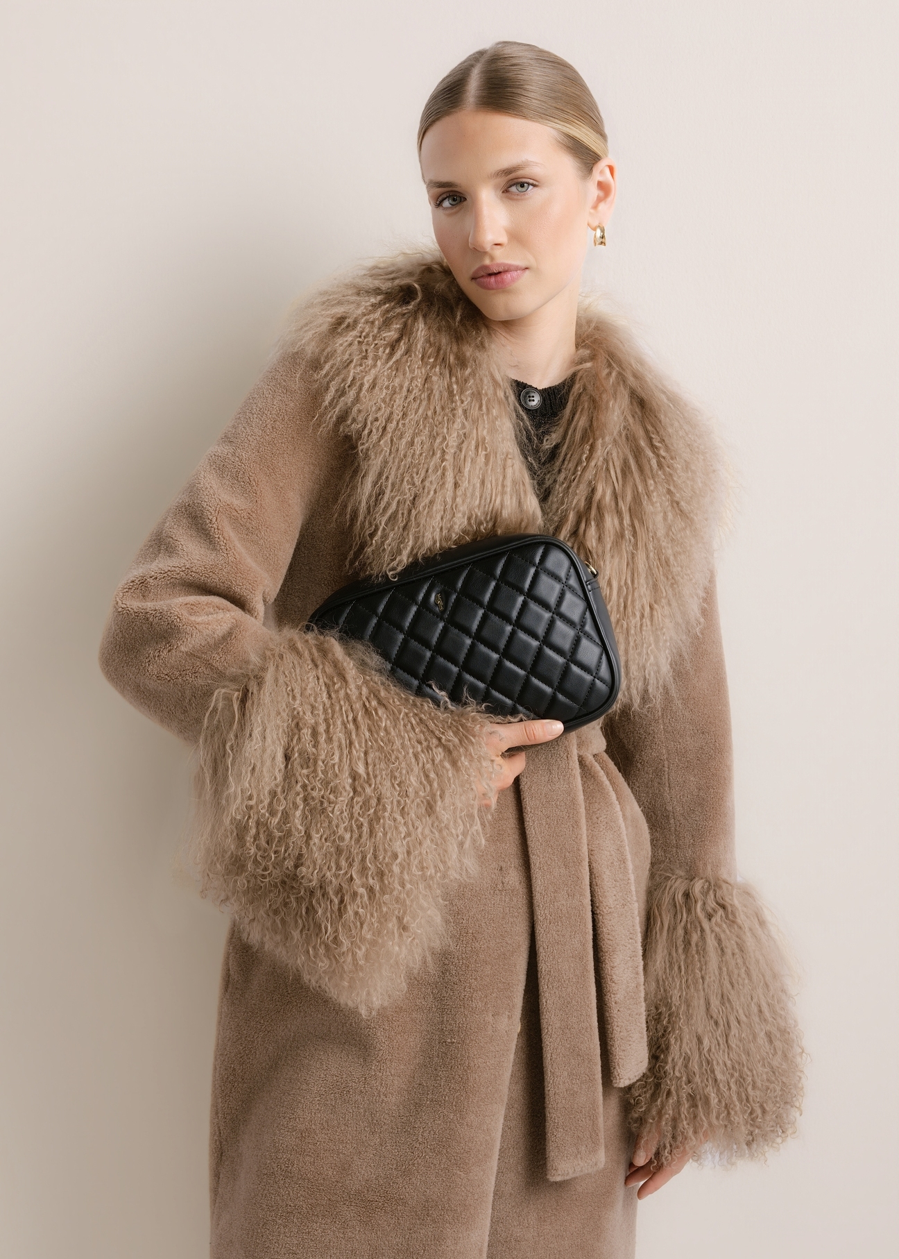 Black quilted women's handbag TOREC-1313-99(Z26); front view of the product held in a model's hand, against a light background.