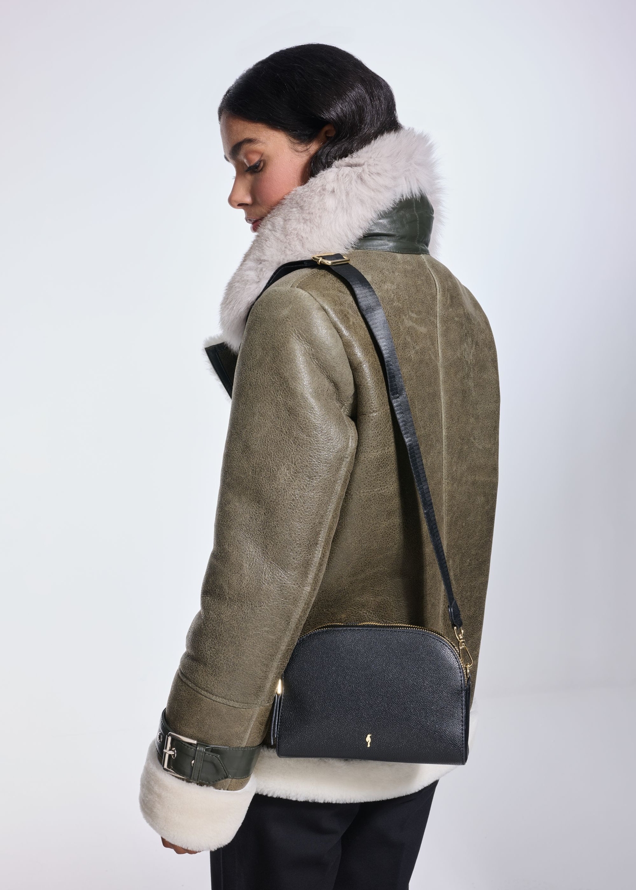 Black small women's handbag TOREC-0036E-99(Z25), front view of the product on a model. Half of the silhouette visible.