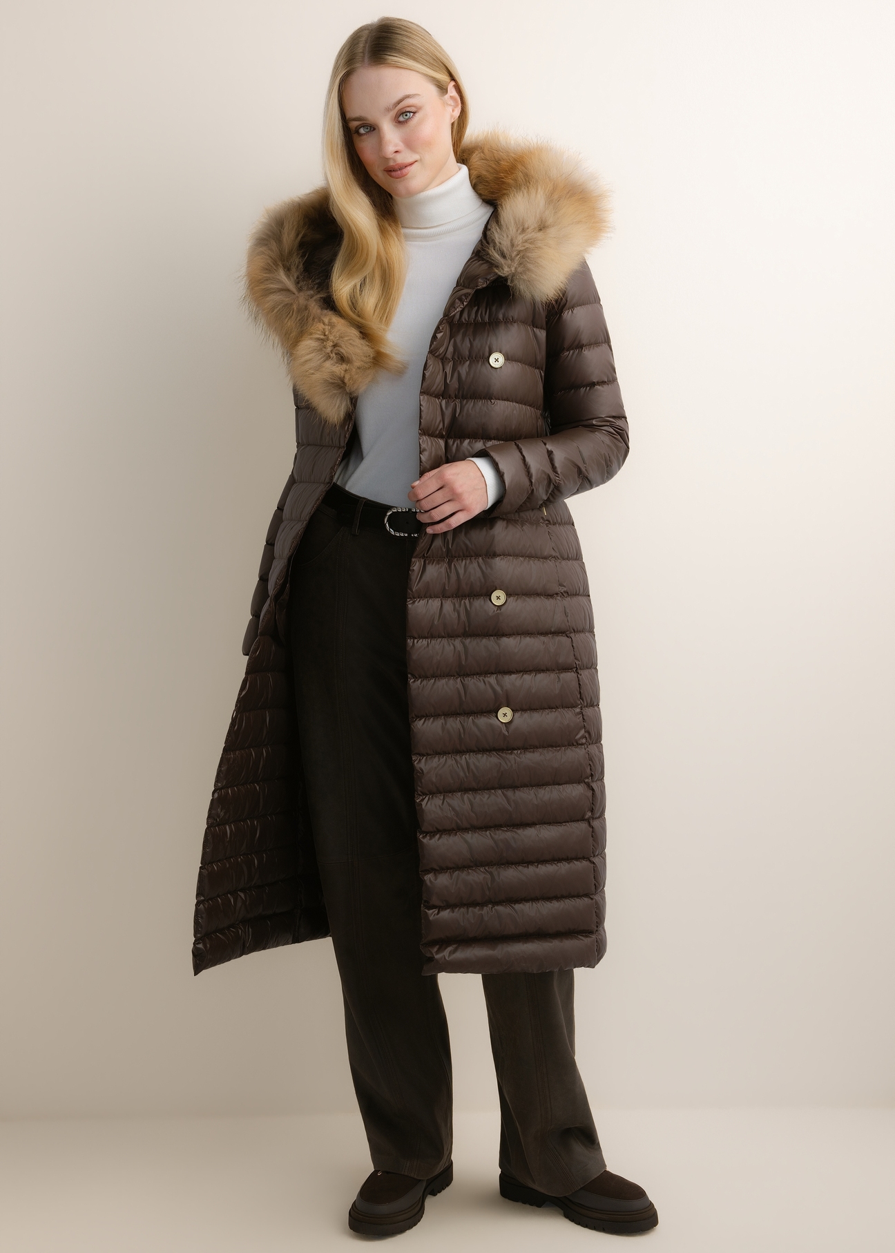 Dark brown long women's jacket with fur KURDT-0706-1I(Z26), front view of the product on the model. Full body visible.