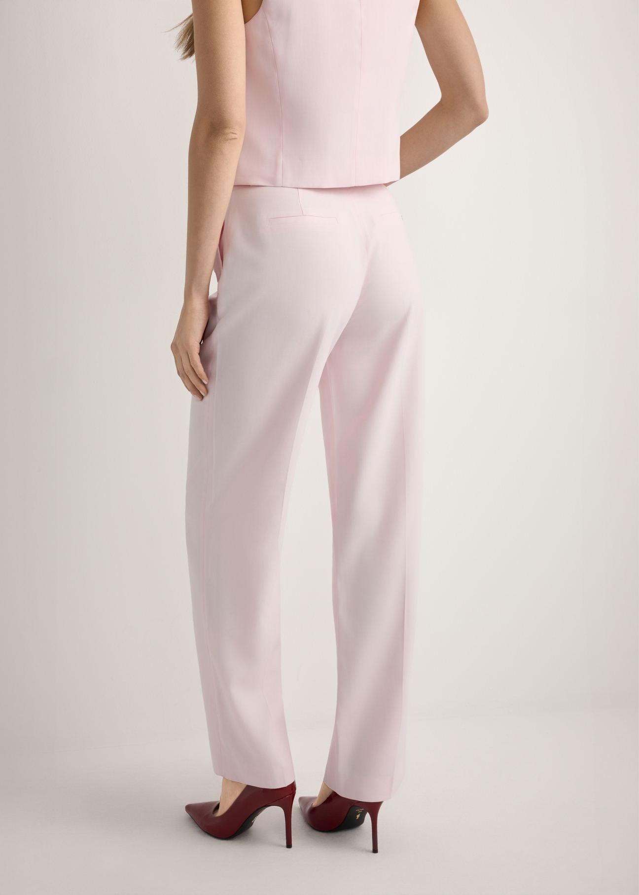 Light pink elegant women's trousers SPODT-0106A-5A(W26), product view from the back on the model, half of the silhouette visible.