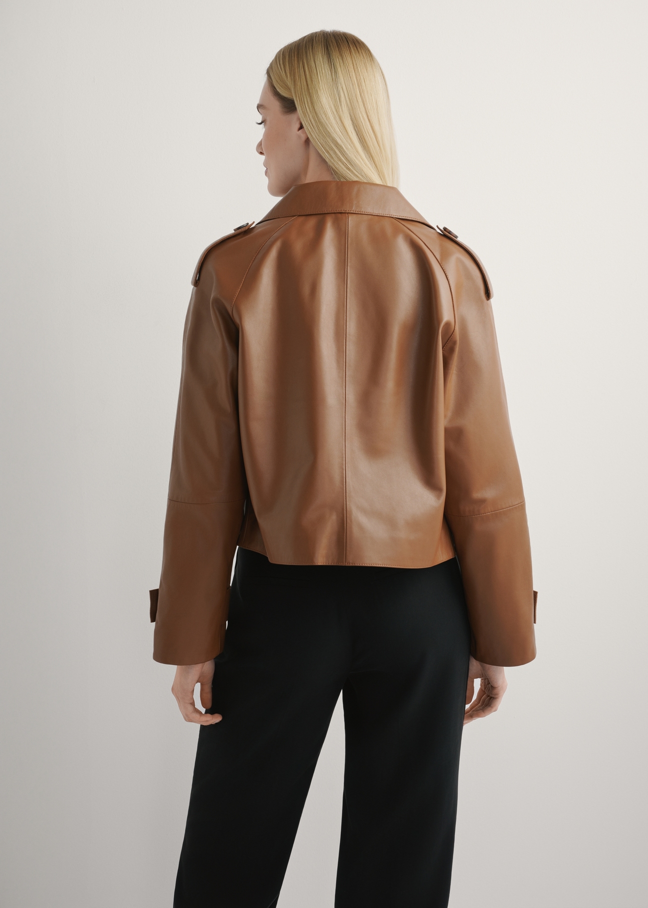 Women's oversized short leather jacket in camel color KURDS-0540-1D(W26), back view of the product on the model. Half of the silhouette visible.