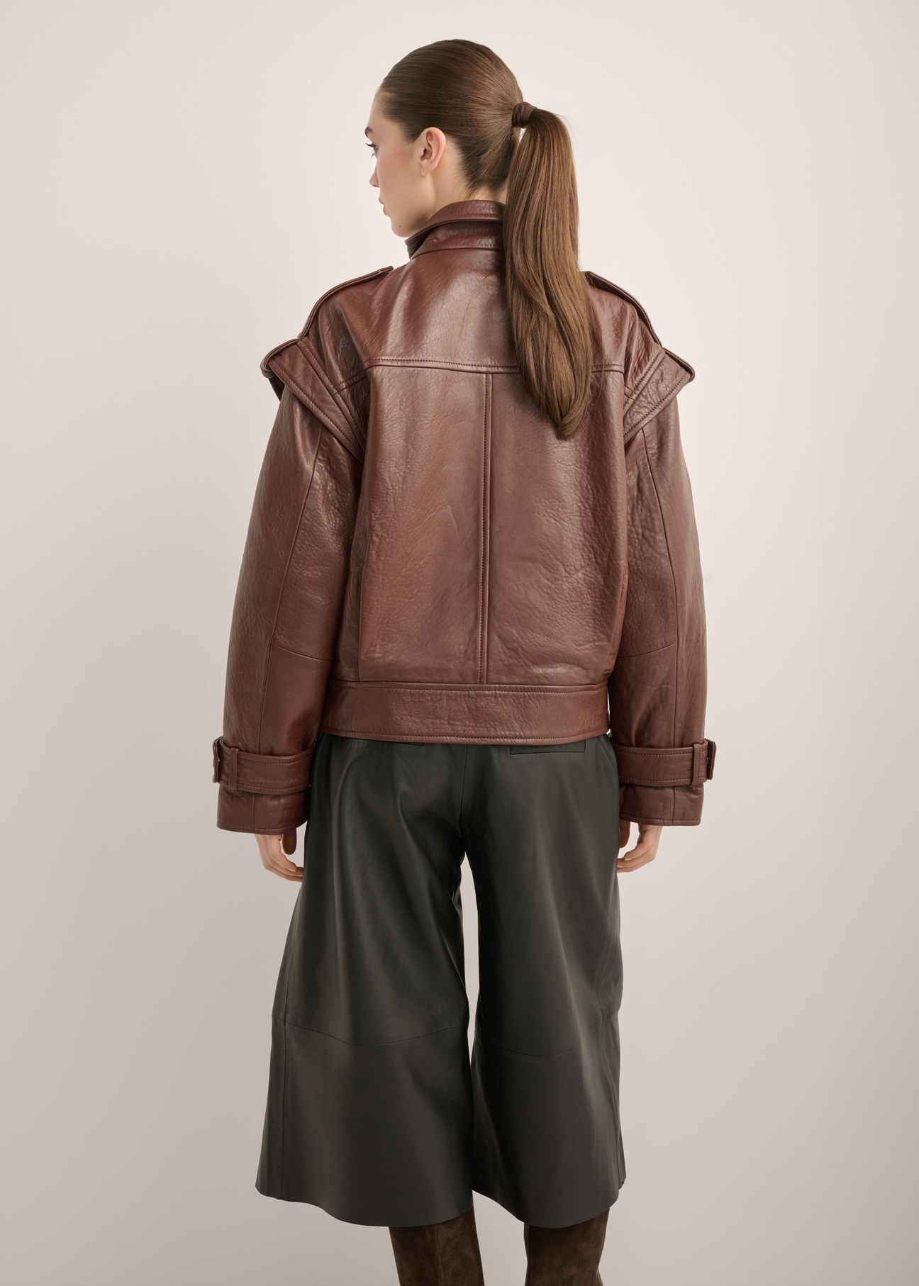 Burgundy oversized women's leather jacket KURDS-0644-4D(Z26), product view from the back on the model. Half of the silhouette visible.