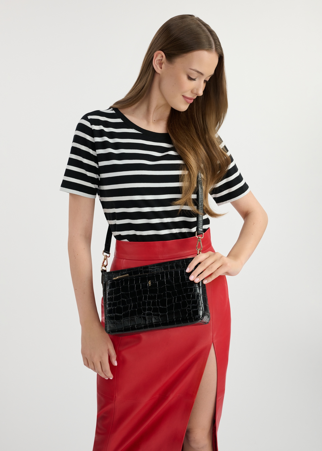 Women's leather messenger bag TORES-0940D-99(W25), diagonal view of the product on the model. Half of the silhouette visible.