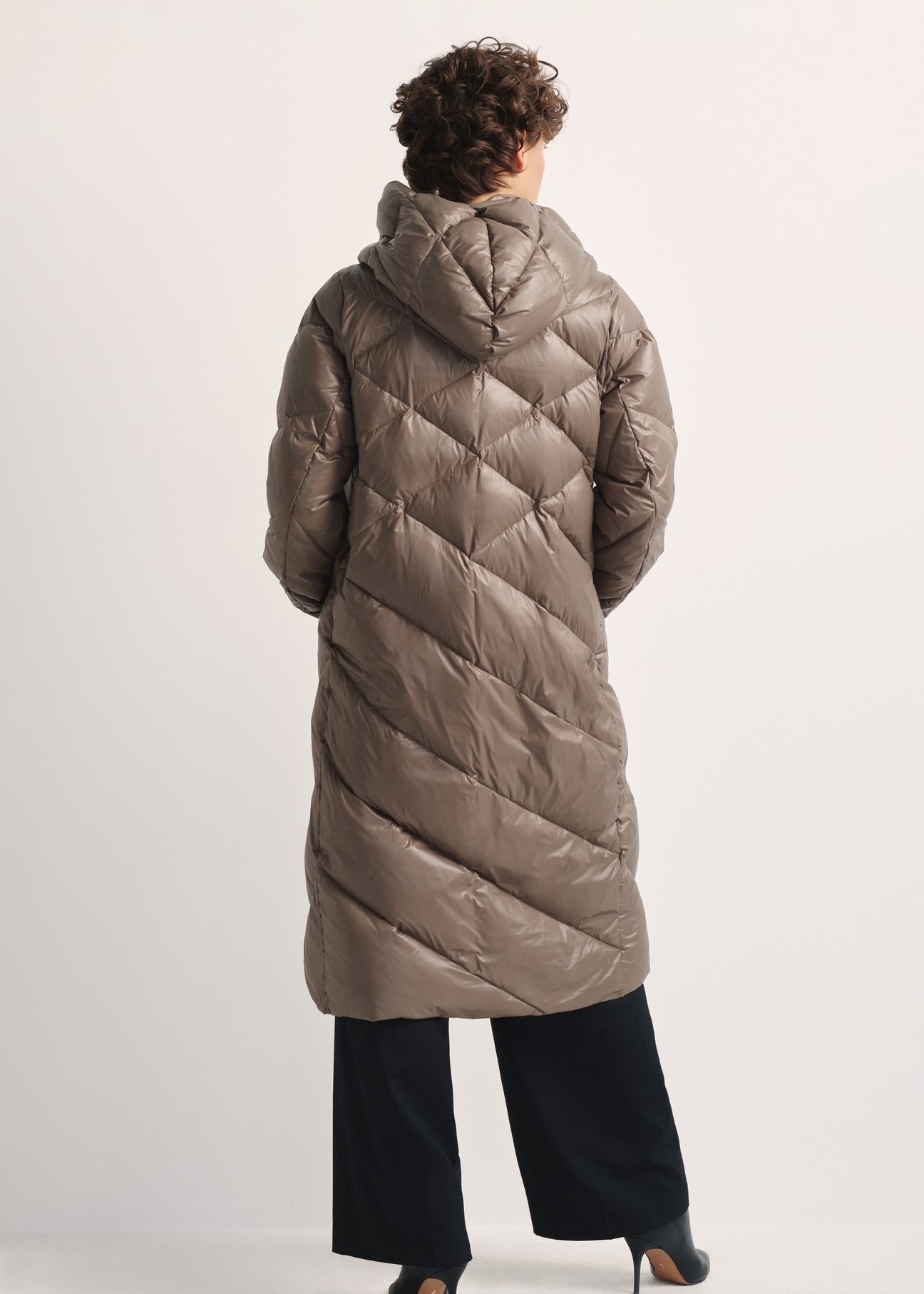 Long olive women's winter jacket KURDT-0542A-57(Z25), product view from the back on the model, the whole silhouette is visible.