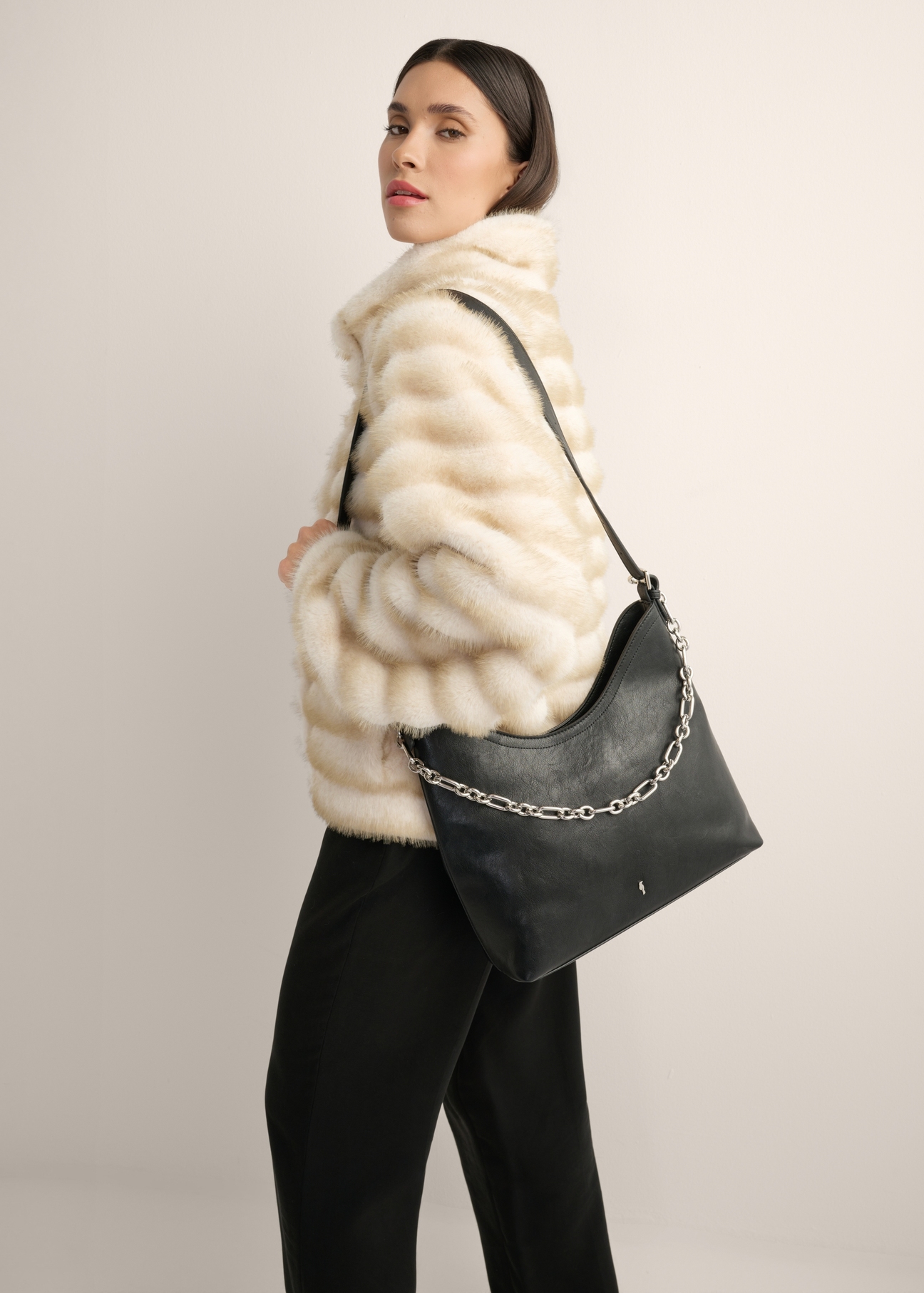Black women's handbag with a jewelry accent TOREC-1325-99(Z26), front view of the product on a model, half of the silhouette visible.