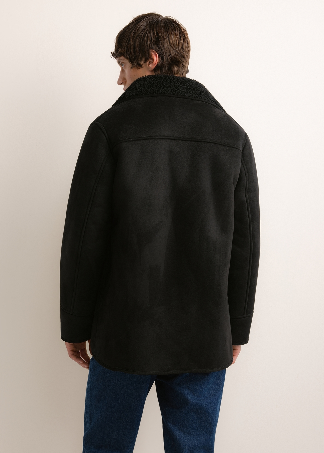 Men's black shearling coat KOZMP-0011-99(Z26), rear view on a model. Half of the figure is visible.