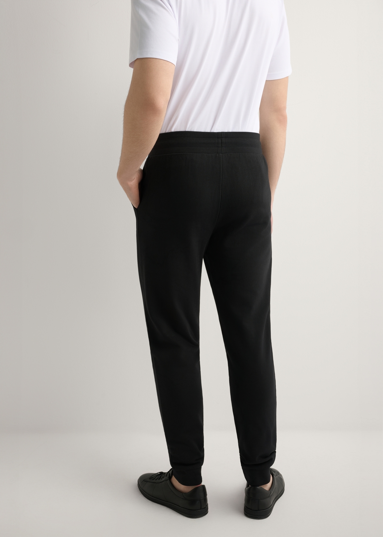 Men's black sweatpants SPOMT-0017-99(W26), product view from the back on the model, half of the silhouette visible.