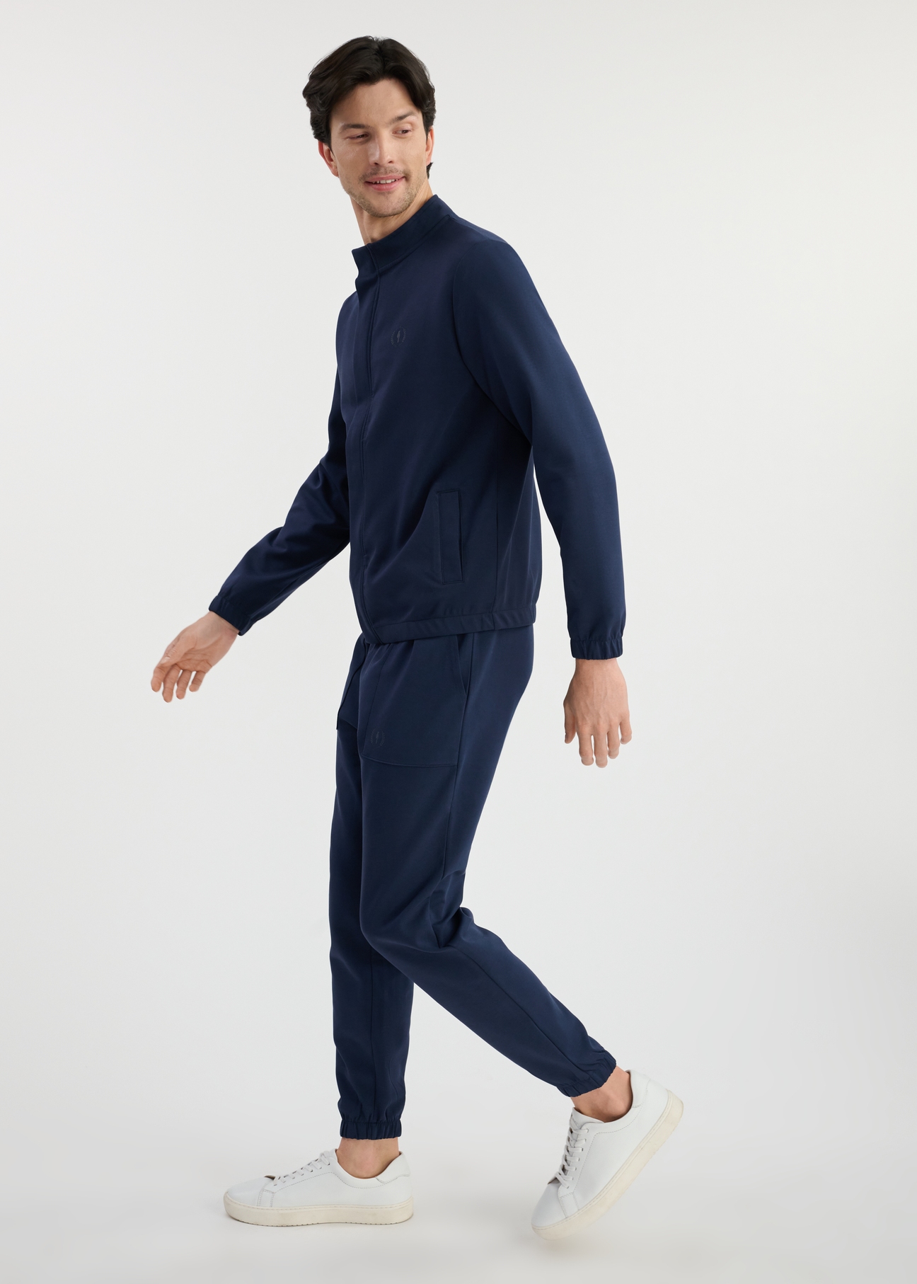 Navy blue men's sweatpants SPOMT-0109-69(W25) - side view on model on white background. Full silhouette visible.
