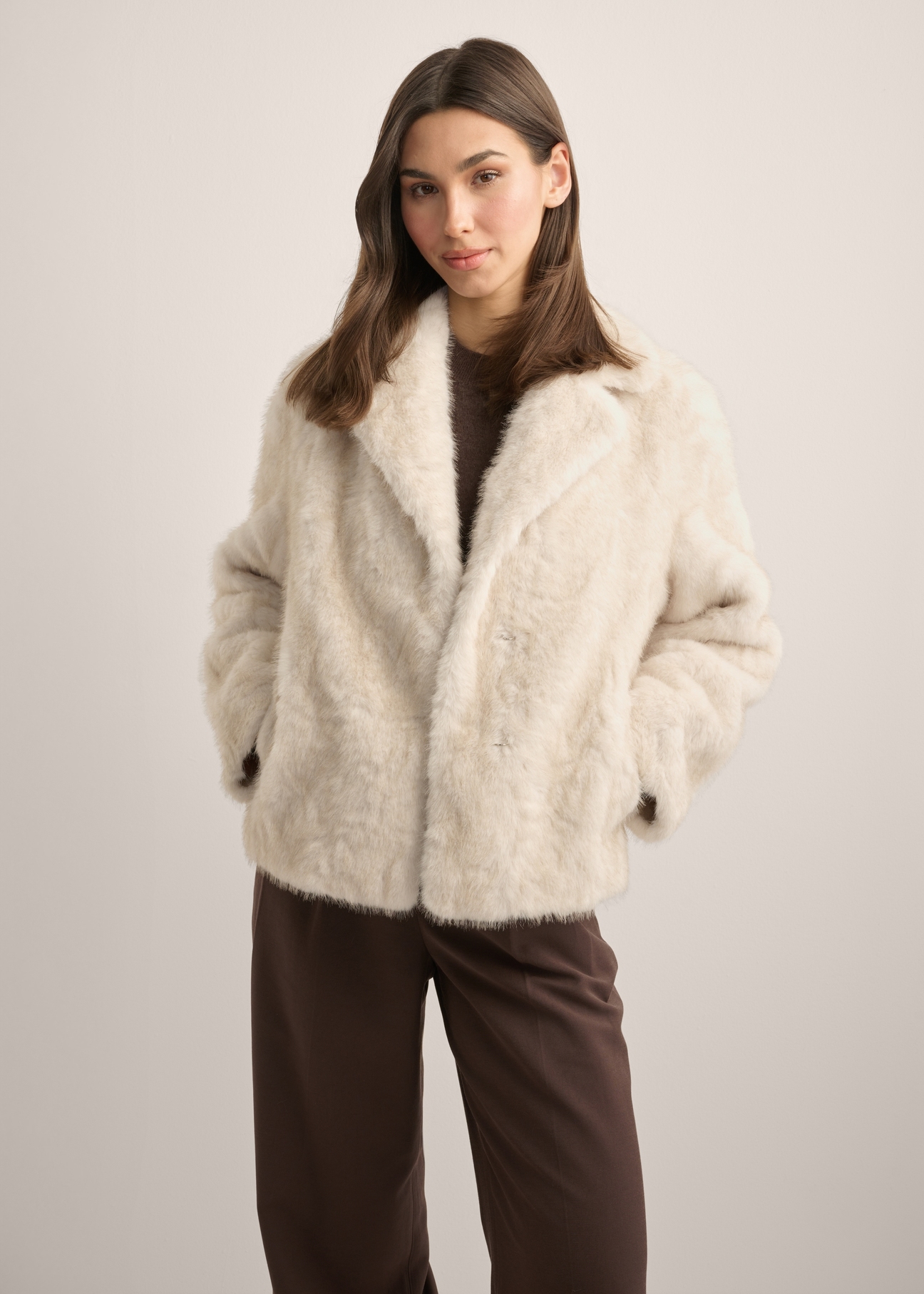 Beige short women's fur coat FUTDP-0058-1A(Z26), front view of the product on the model. Half of the silhouette visible.