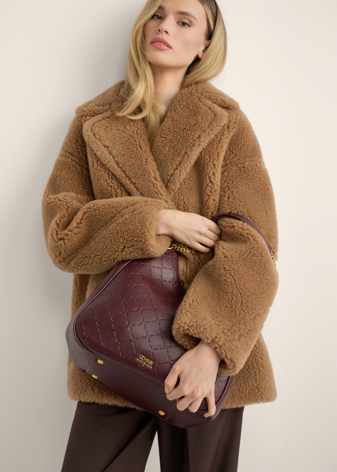 Women's burgundy monogrammed shopper bag TOREC-1283-4P(Z26), front view of the product on the model. Half of the silhouette visible.