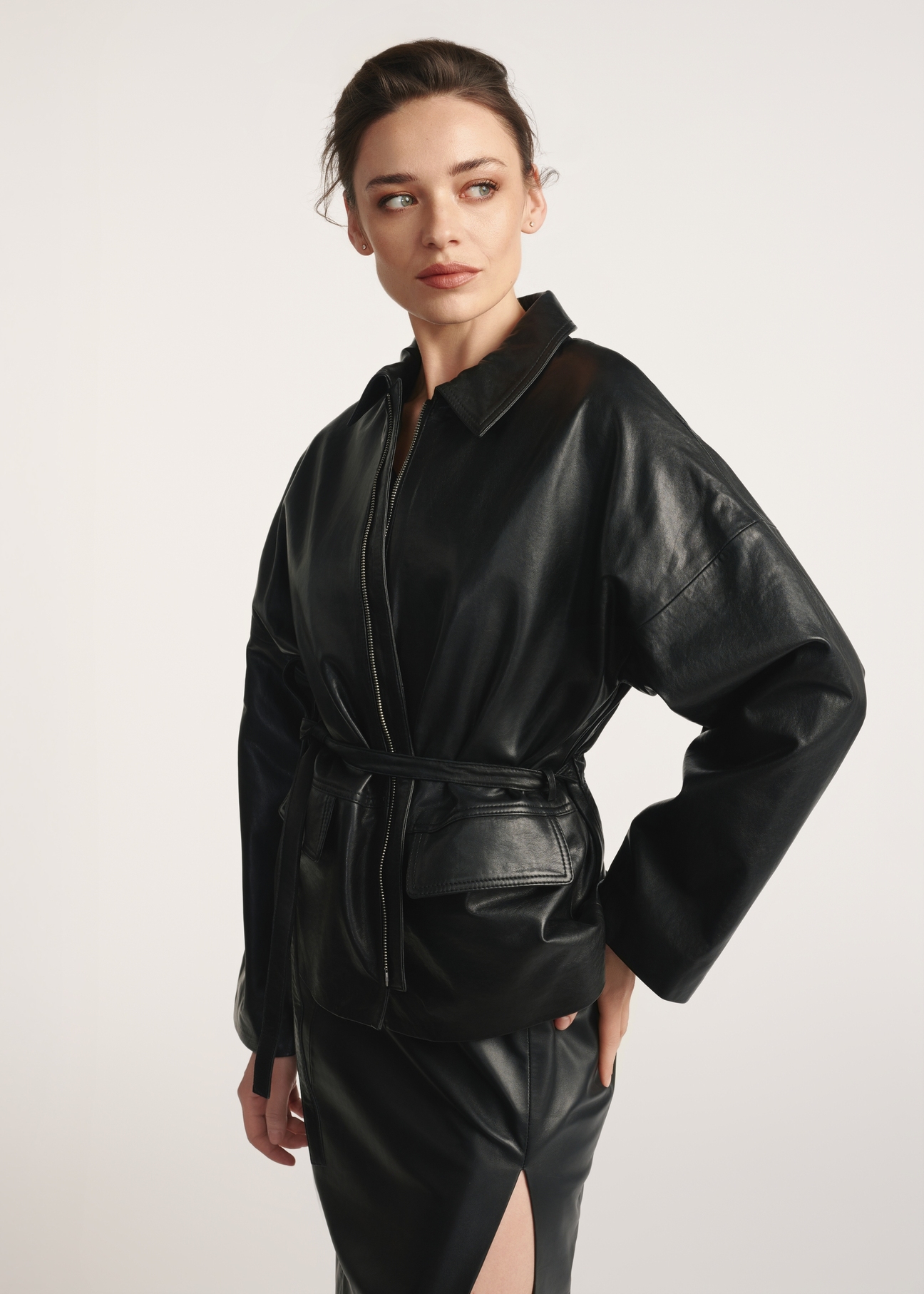 Black women's leather jacket with ties KURDS-0547-2861(Z25), front view of the product on the model, half of the silhouette visible.