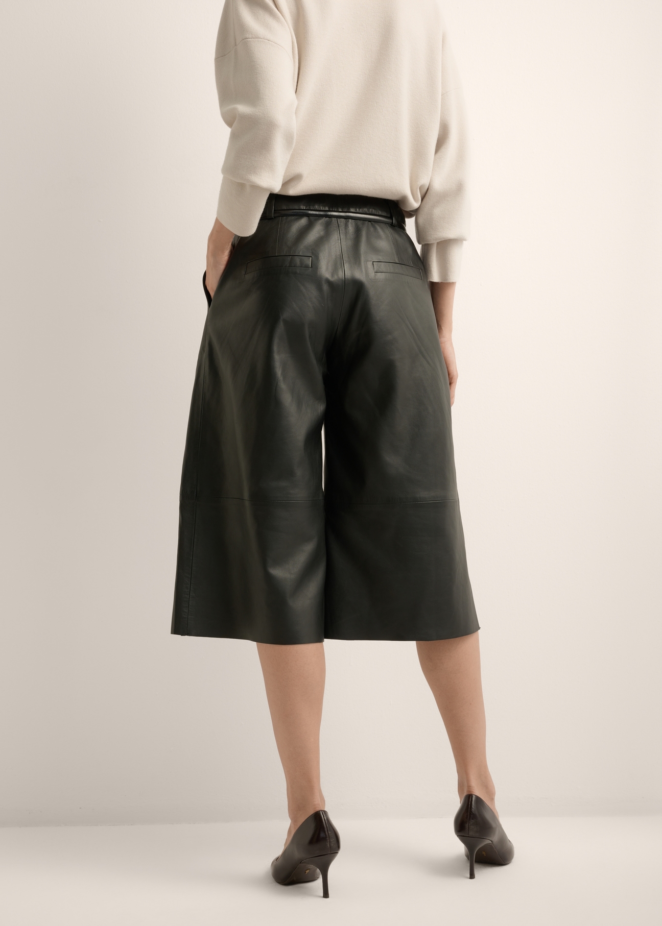 Women's wide-leg black leather trousers SPODS-0049-99(Z26) - back view of the product, on a model, against a light background. Half of the silhouette visible.