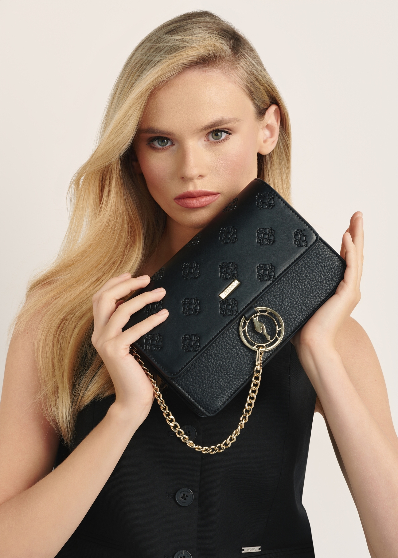 Black women's handbag with monogram TOREC-0536C-99(Z25), view of the product in the model's hands.