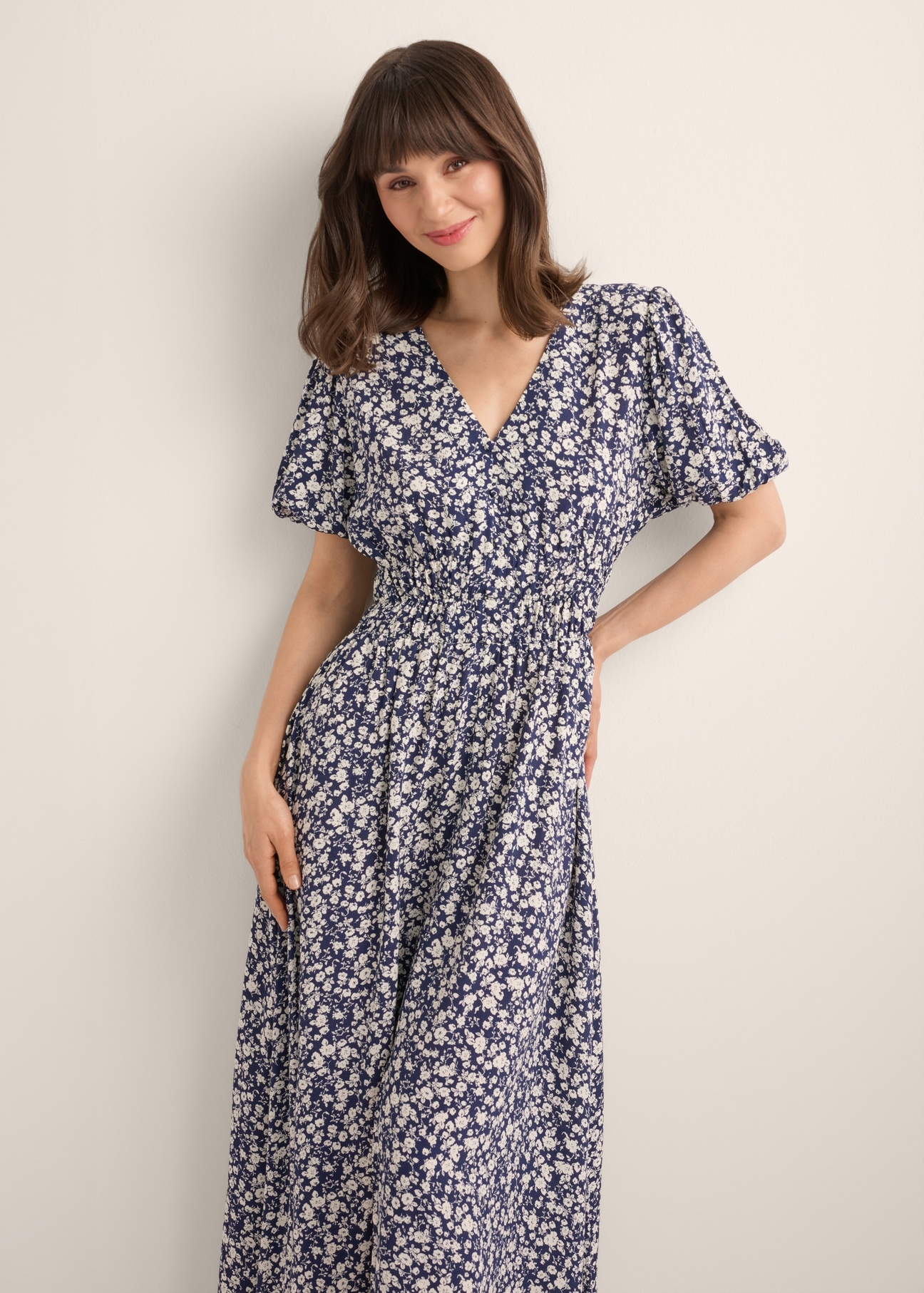 Long floral dress in navy blue SUKDT-0191-7I(W26), front view of the product on the model. Half of the silhouette visible.