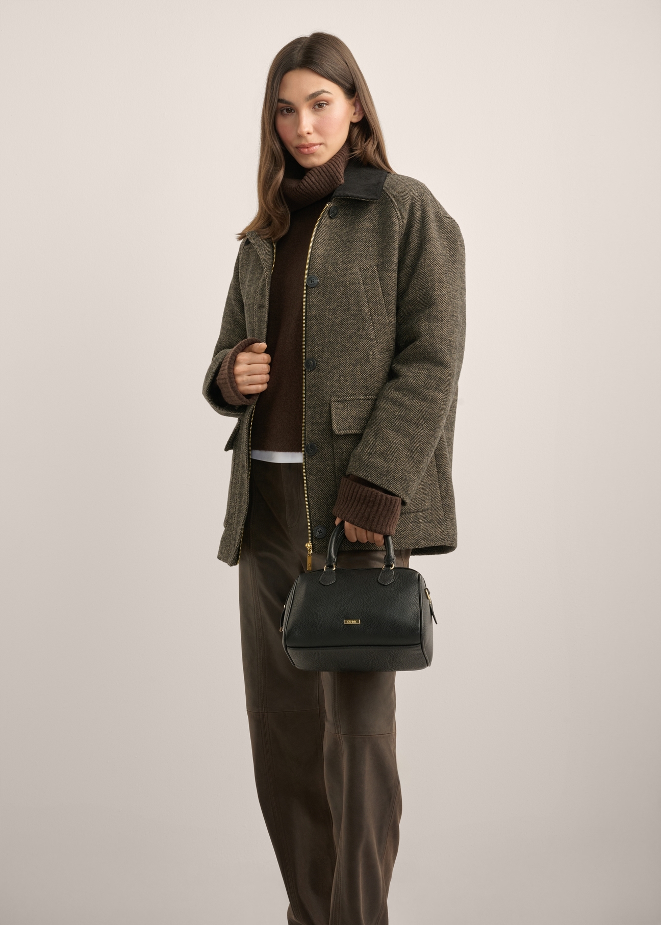 Black leather women's handbag TORES-1381-99(Z26), front view of the product in the model's hand.