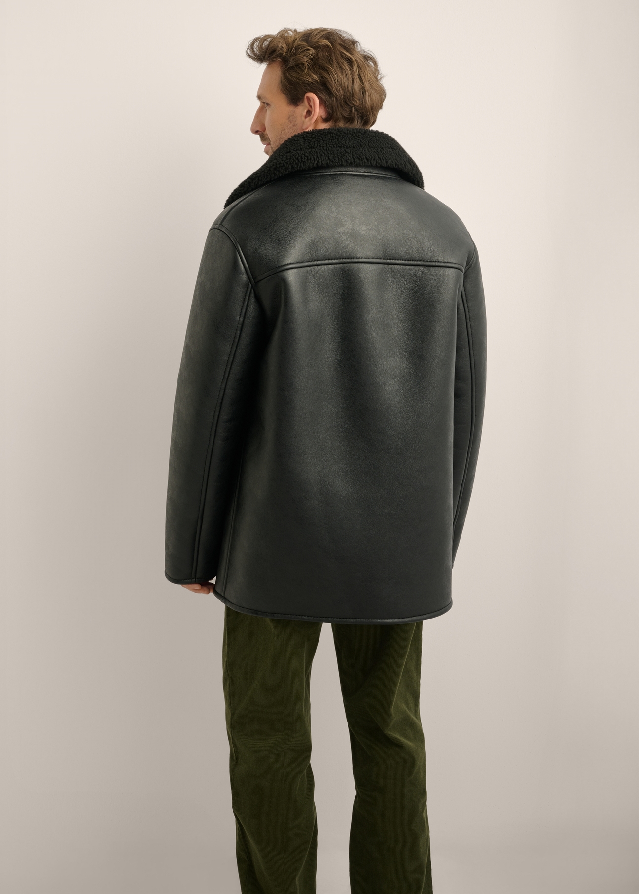 Men's black sheepskin coat KOZMP-0012-99(Z26), rear view of the product on the model. Half of the silhouette visible.