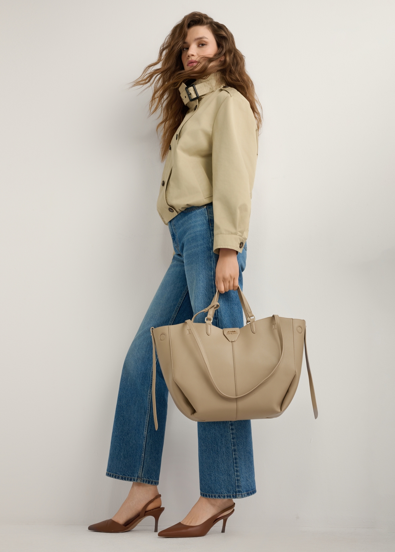Beige large shopper bag TOREC-1201-1B(W26), view of the product in the model's hand. Full body visible.