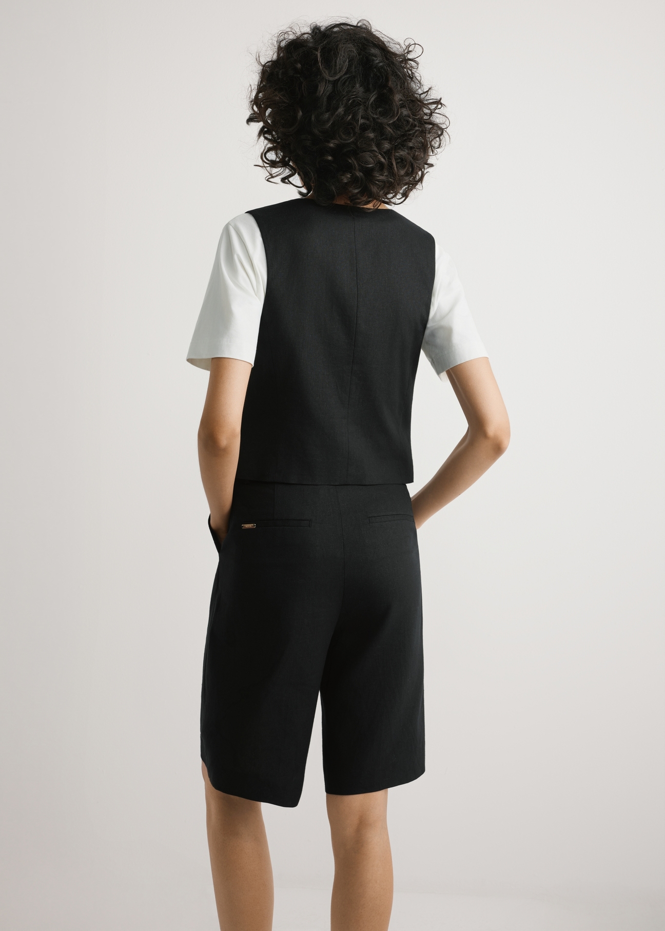 Black viscose and linen vest KAMDT-0038-99(W26) - product view from the back, on a model, on a light background, half of the silhouette visible.
