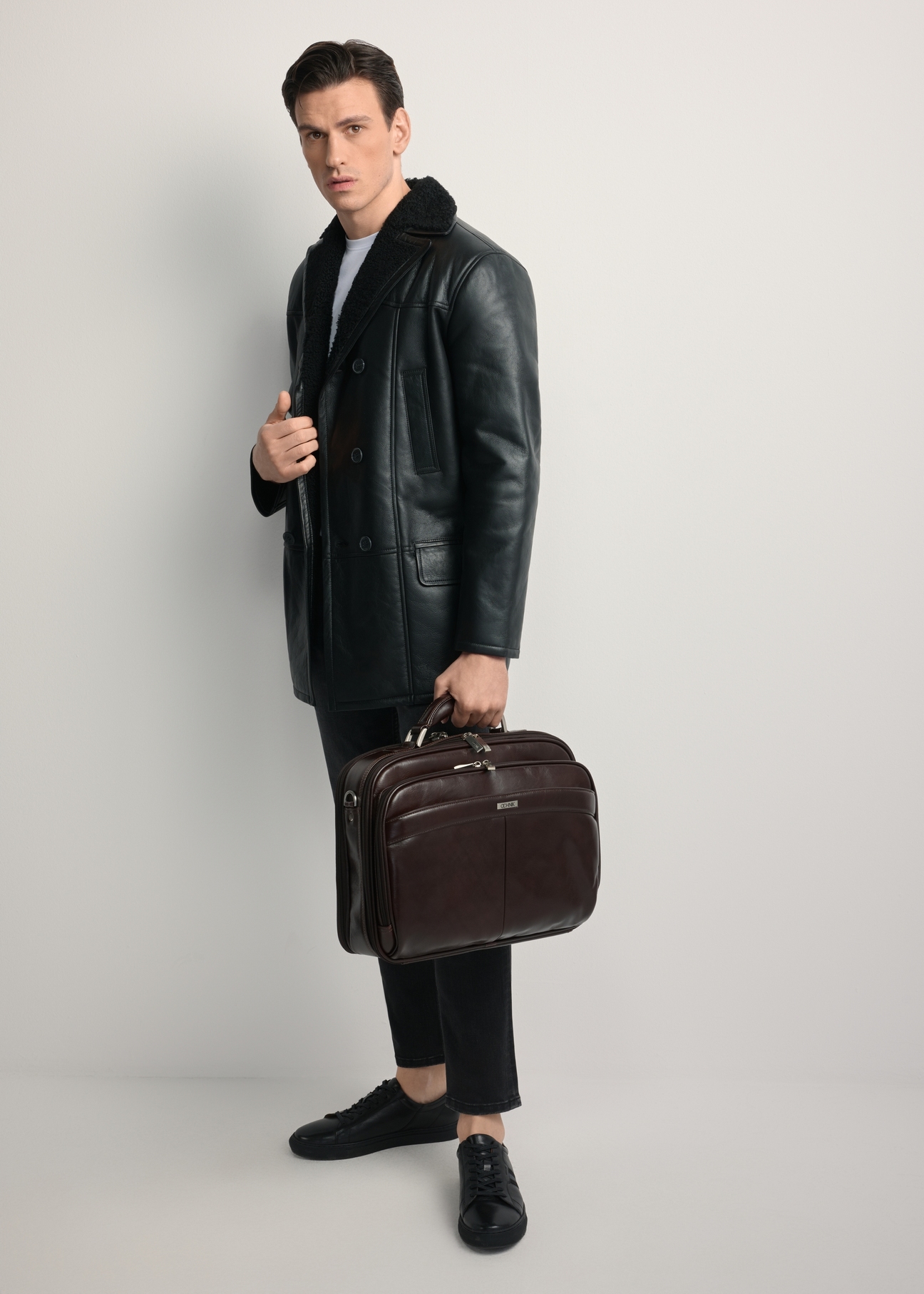 Brown leather men's laptop bag TORMS-0482-89(Z25) - front view of the product, held by the model. Full body view.