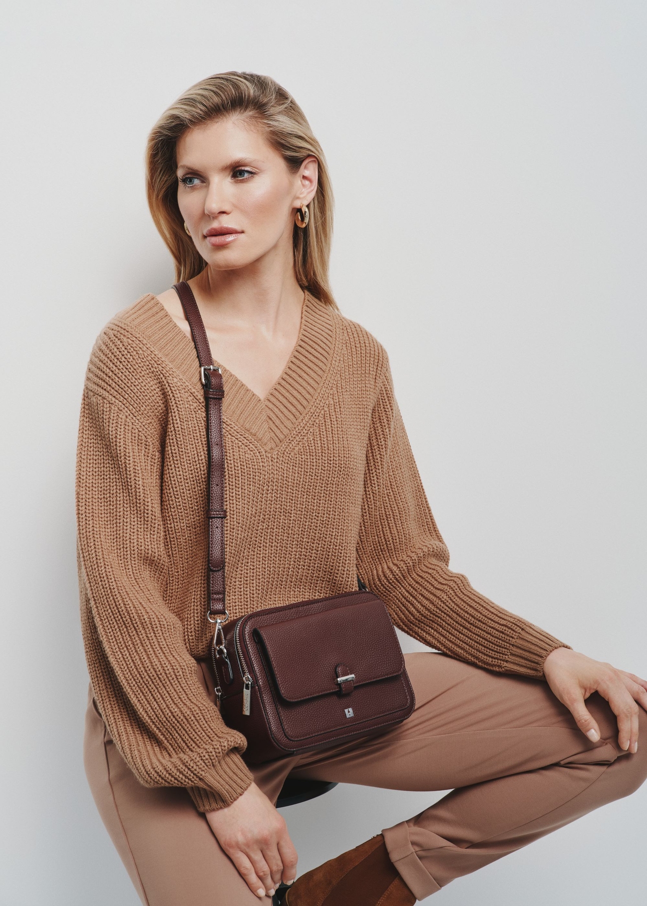 Burgundy two-compartment shoulder bag TOREC-0405C-49(Z25), product view on the model. Half of the silhouette visible.