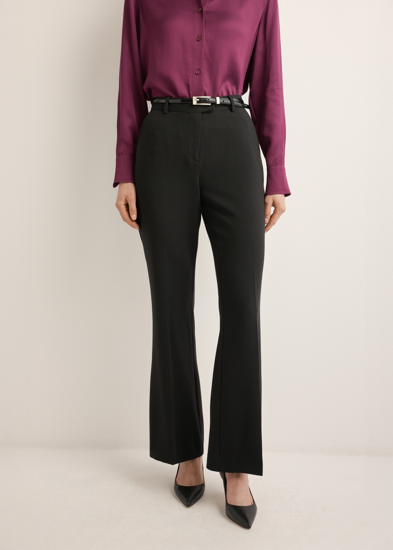 Women's black pleated trousers SPODT-0128-99(Z26), front view of the product on the model. Half of the silhouette visible.