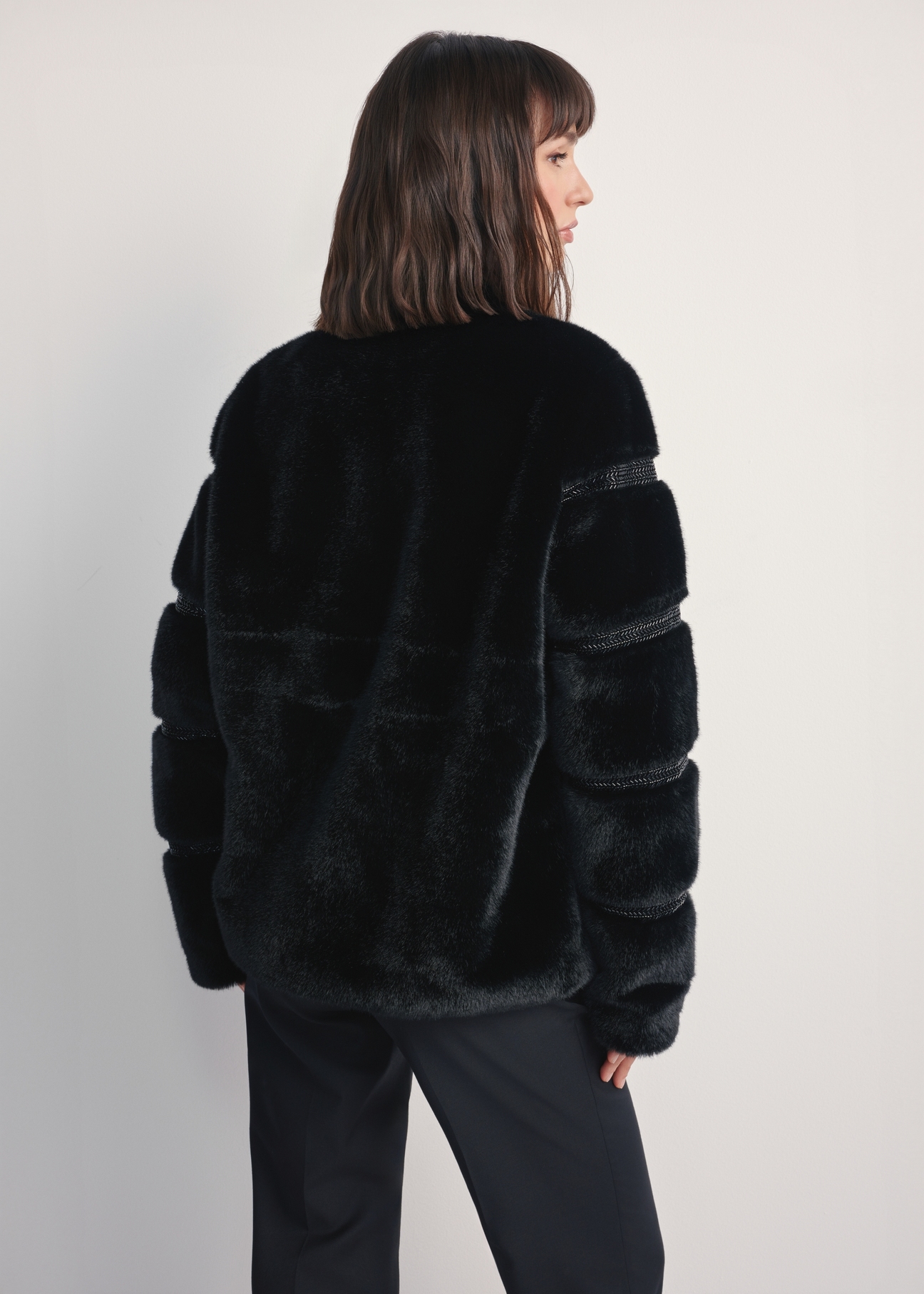 Women's black fur coat with appliqués FUTDP-0067-99(Z25) - back view of the product on a model against a white background. Knee-length silhouette visible.