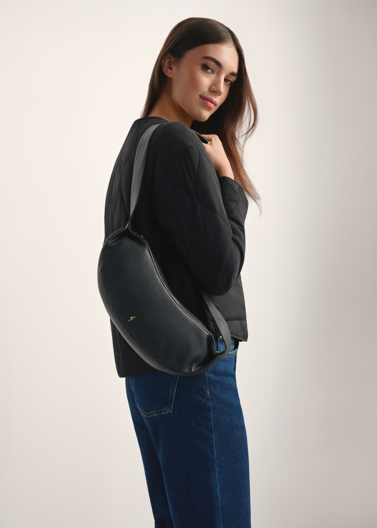 Black leather baguette-style handbag TORES-1238-99(W26), front view of the product on a model, half of the silhouette visible.