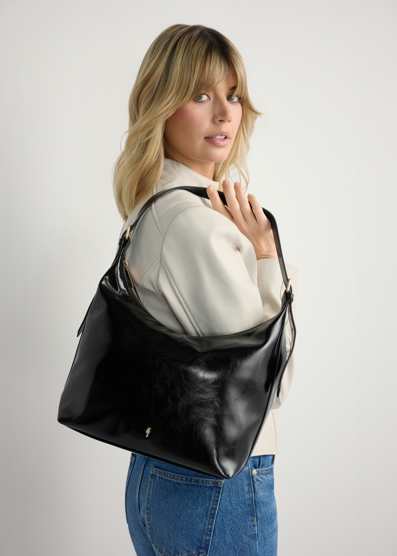 Black women's shoulder bag TOREC-1166-9F(W26), product view on model's shoulder. Half of silhouette visible.