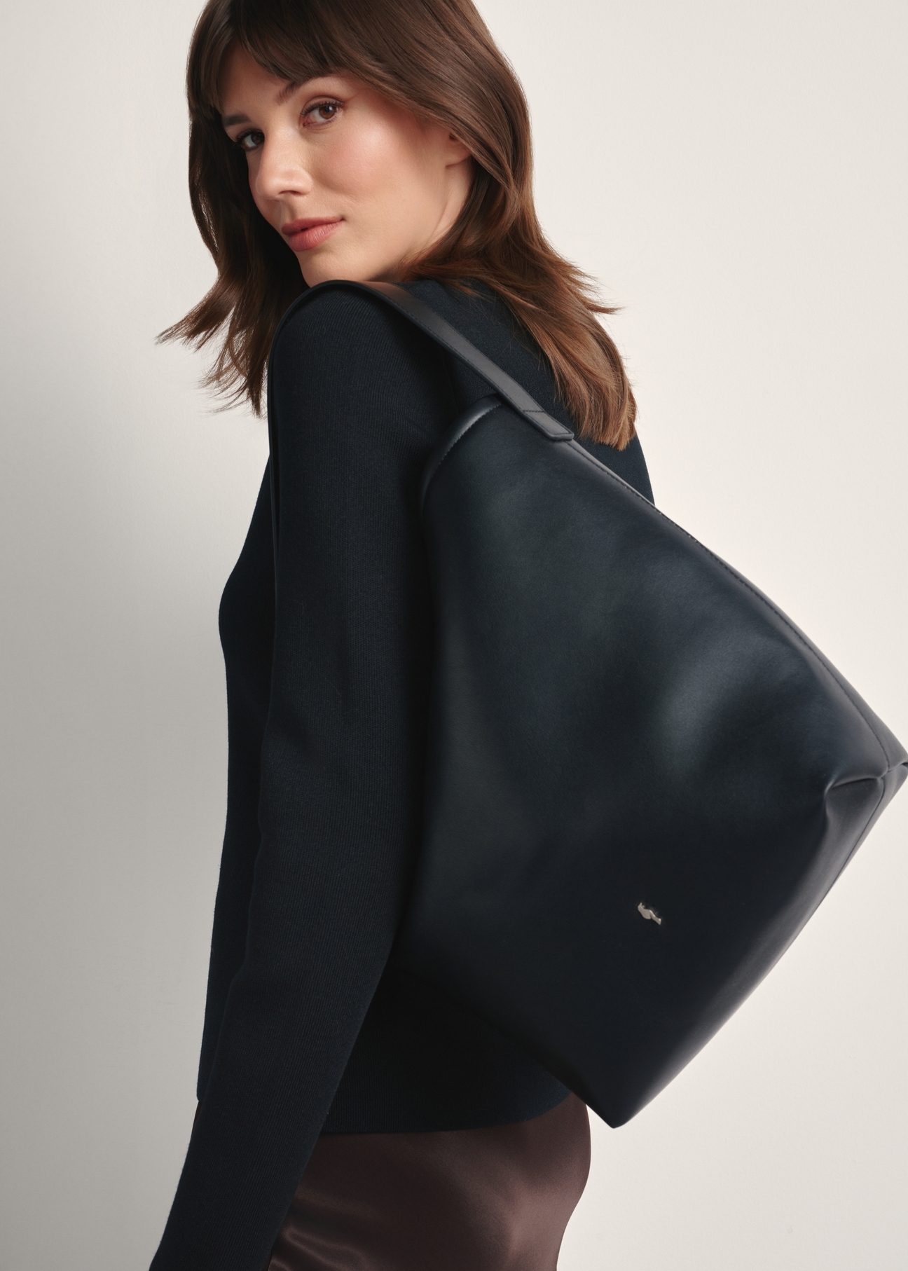 Black women's handbag TOREC-1094-99(Z25), front view of the product on a model, half of the silhouette visible.