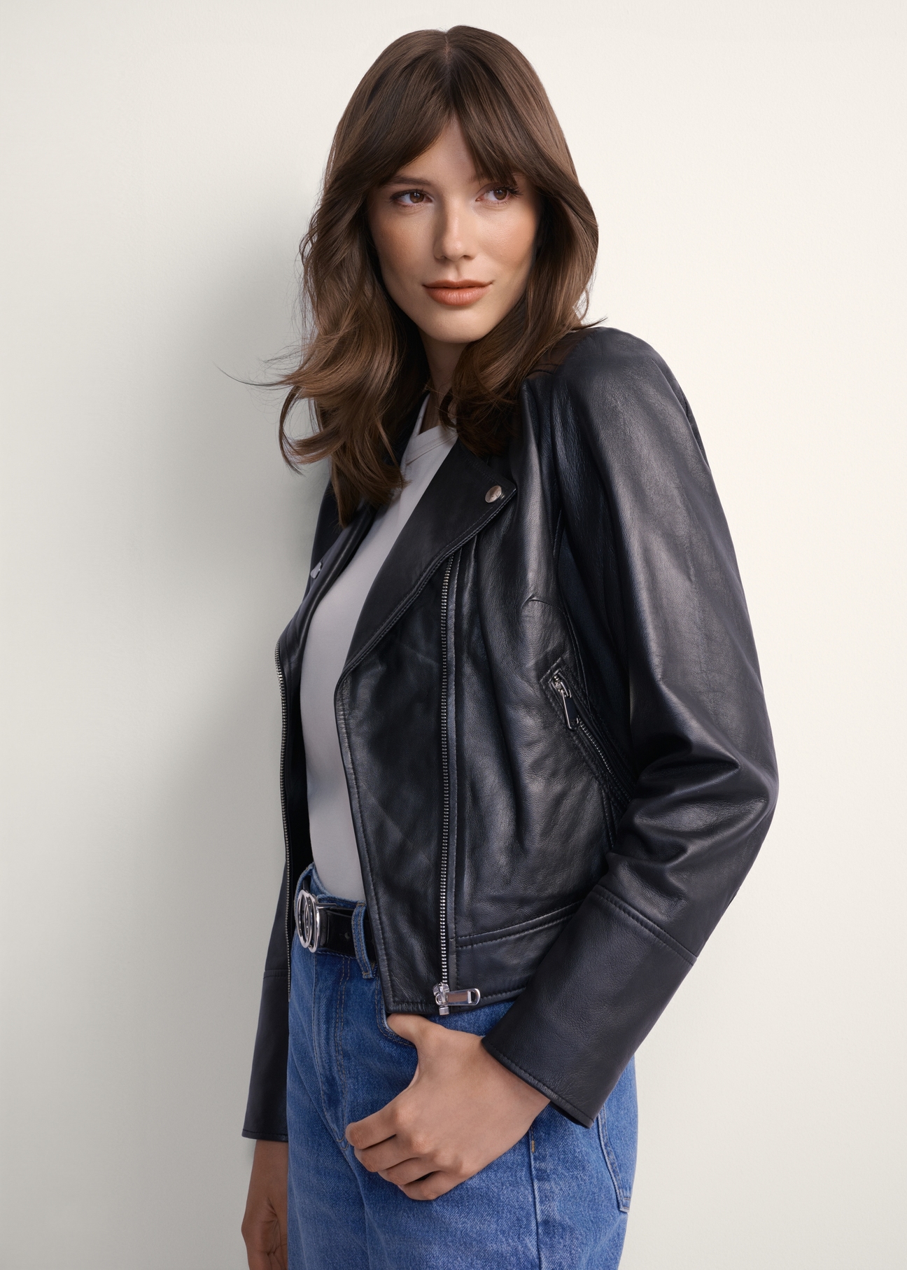 Women's black leather biker jacket KURDS-0273-1110(KS), front view of the product on the model. Half of the silhouette visible.