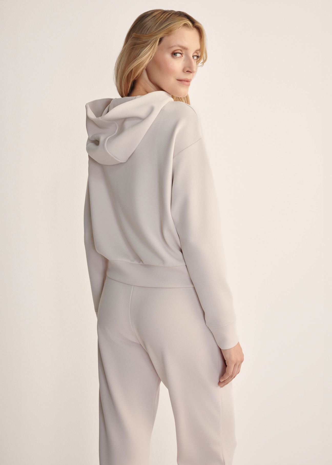 Light beige women's hooded sweatshirt BLZDT-0118-1A(Z26), back view of the product on the model. Half of the silhouette visible.
